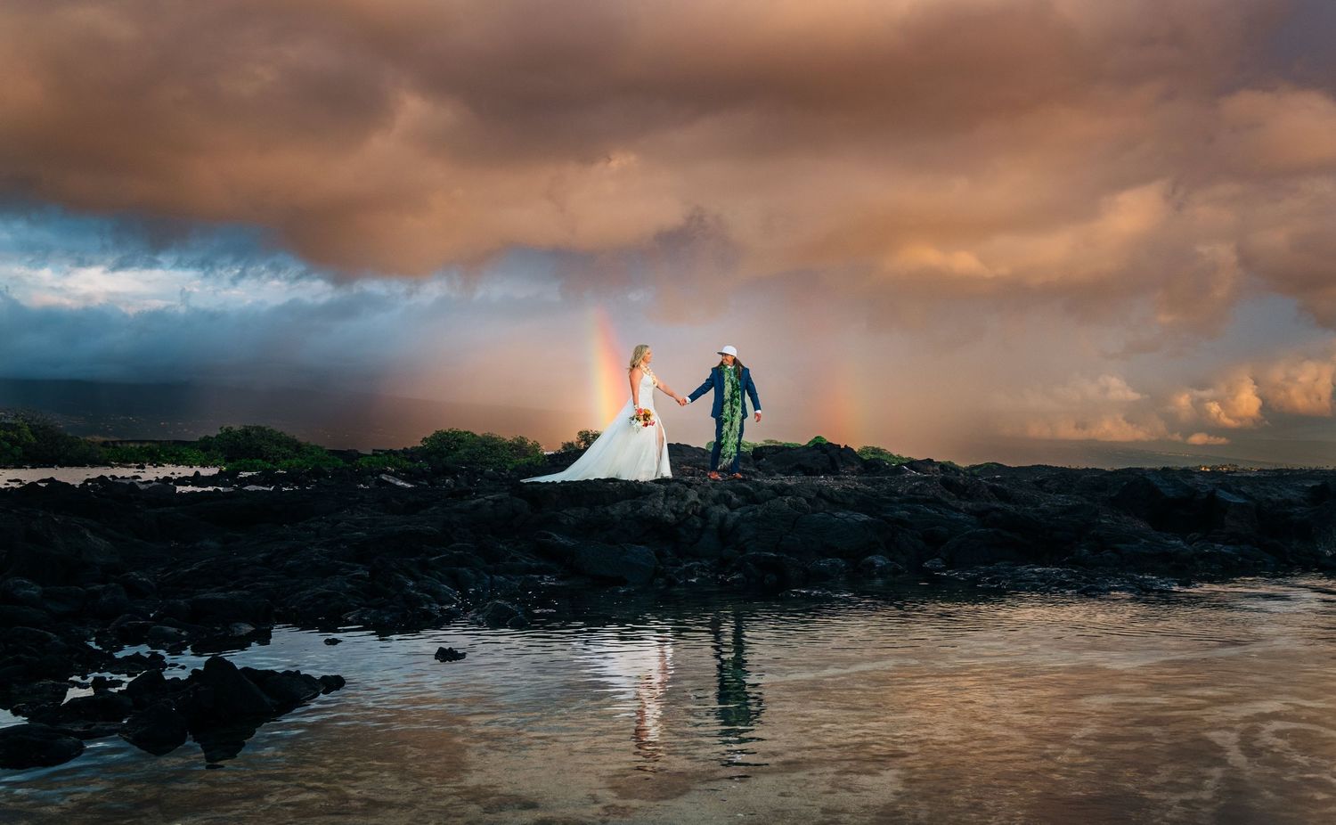 Dramatic sunset over ocean with silhouettes and stormy clouds in panoramic view at Kona Salt Farm, Kona, Big Island Hawaii.
