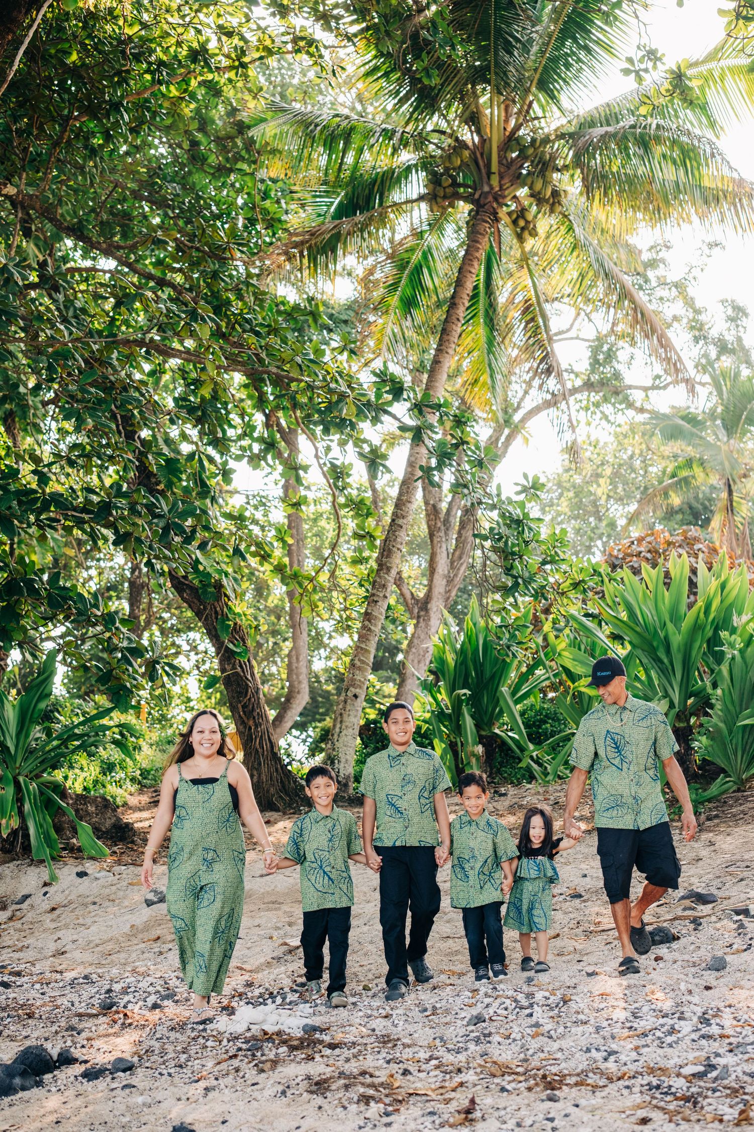 Group walking through tropical forest path wearing matching outfits for wedding party photos in Hilo, Big Island of Hawaii.