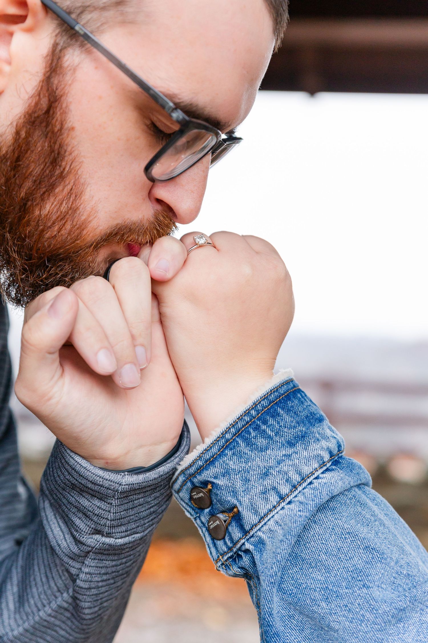 Close-up detail of glasses and denim jacket in a tender moment.