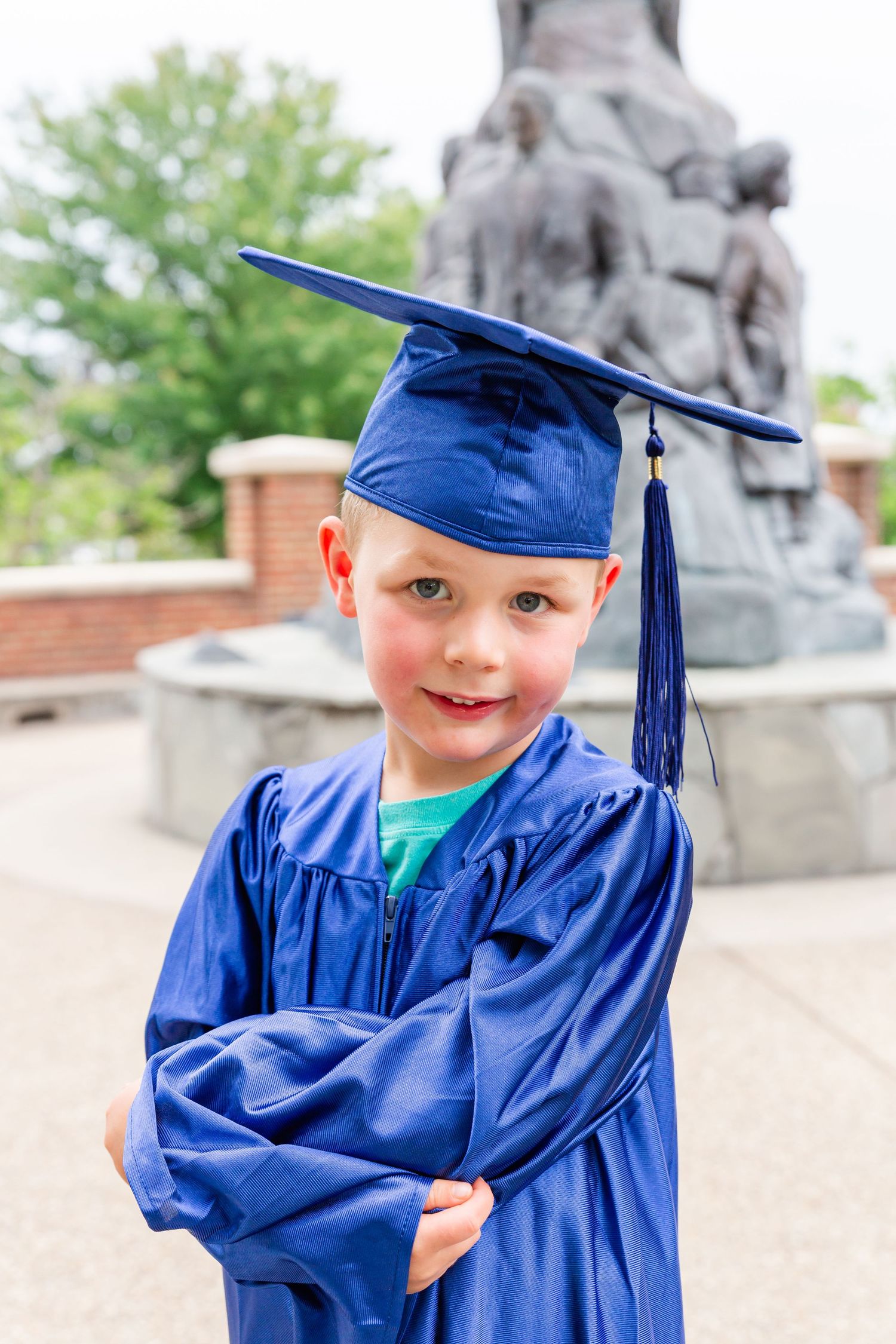 A bright blue graduation cap and gown create joyful moments against a stone wall backdrop.