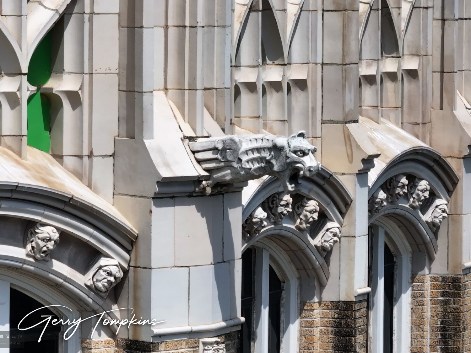 Gothic facade on the Tower Life building with ornate grotesques on arched windows, detailed architecture photography.