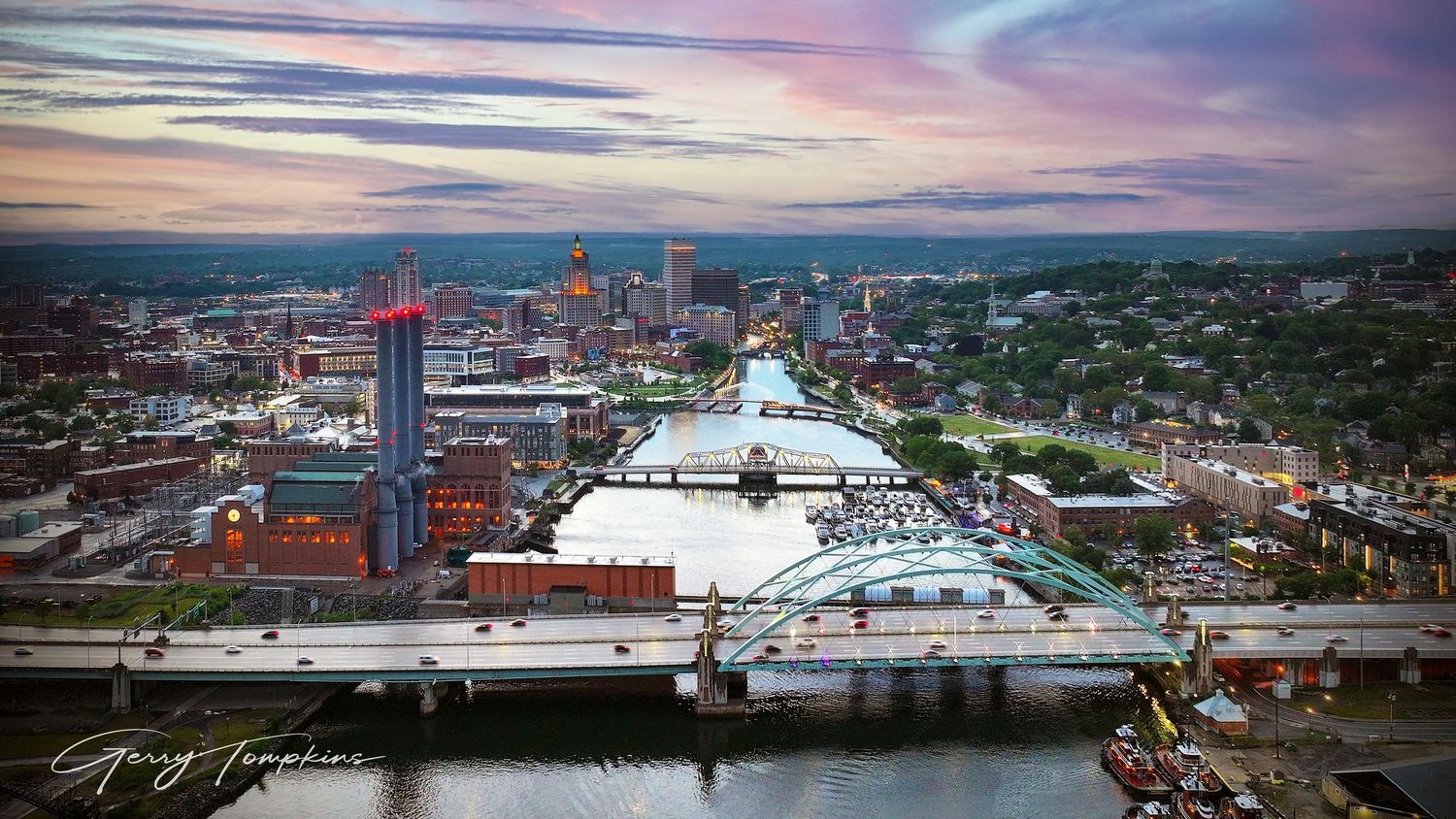 Aerial sunset view of Providence River with bridges and colorful pink sky.