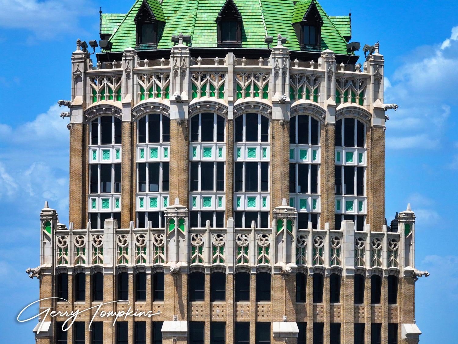 Historic Tower Life building with green roof, Gothic architectural details, and decorative facade against a blue sky.