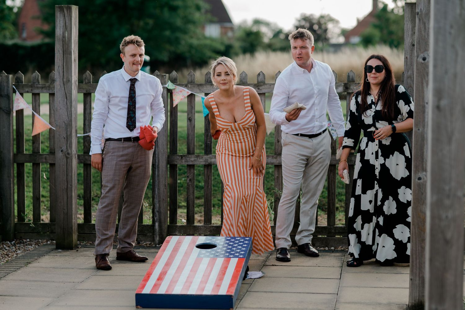 Wedding guests gather on an outdoor patio during a summer celebration.