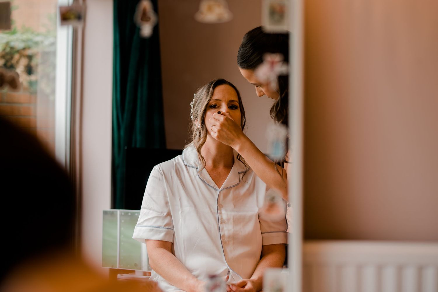 A person in a white shirt sits thoughtfully by a window in warm, natural lighting.
