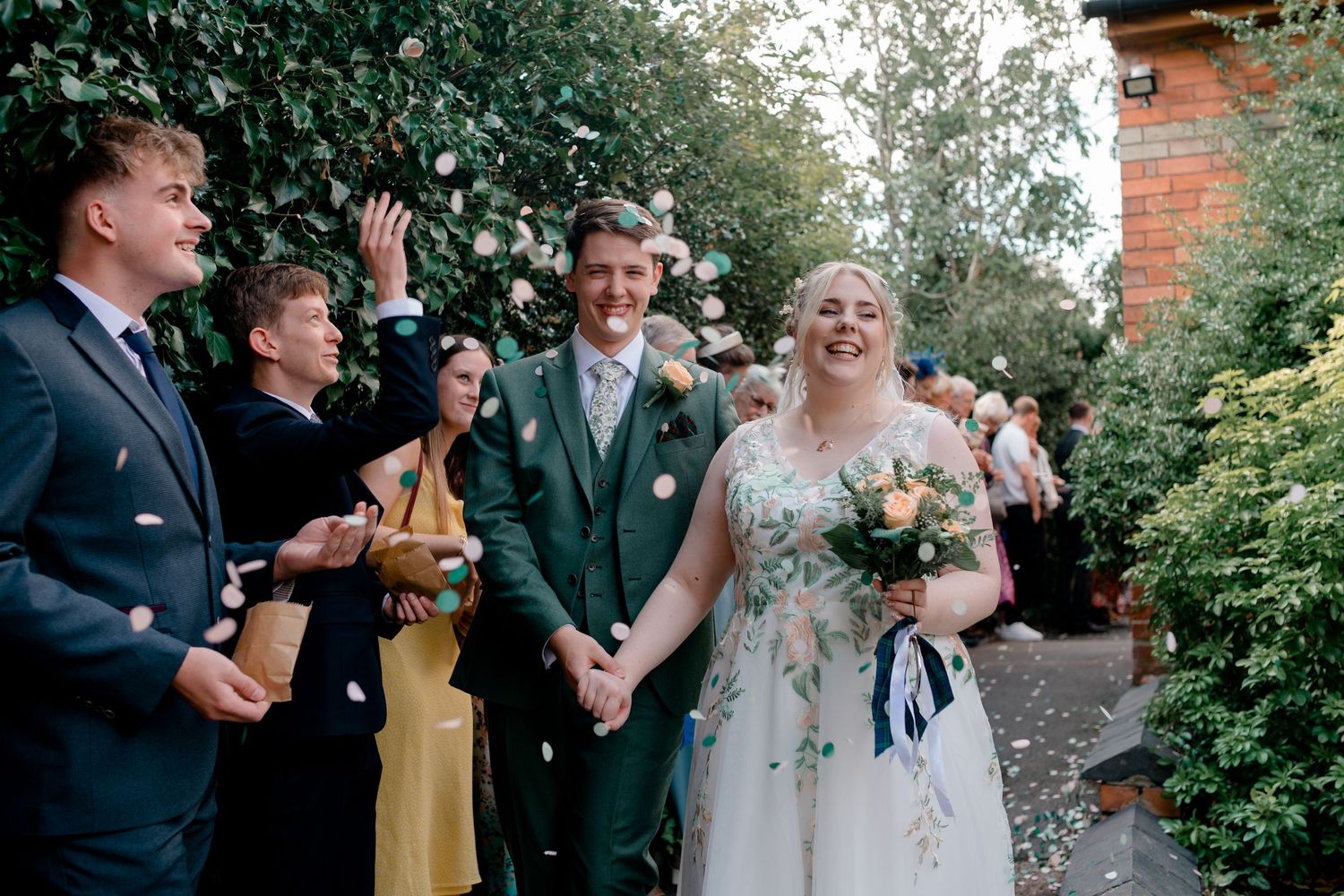 Wedding celebration in a garden setting with guests celebrating.