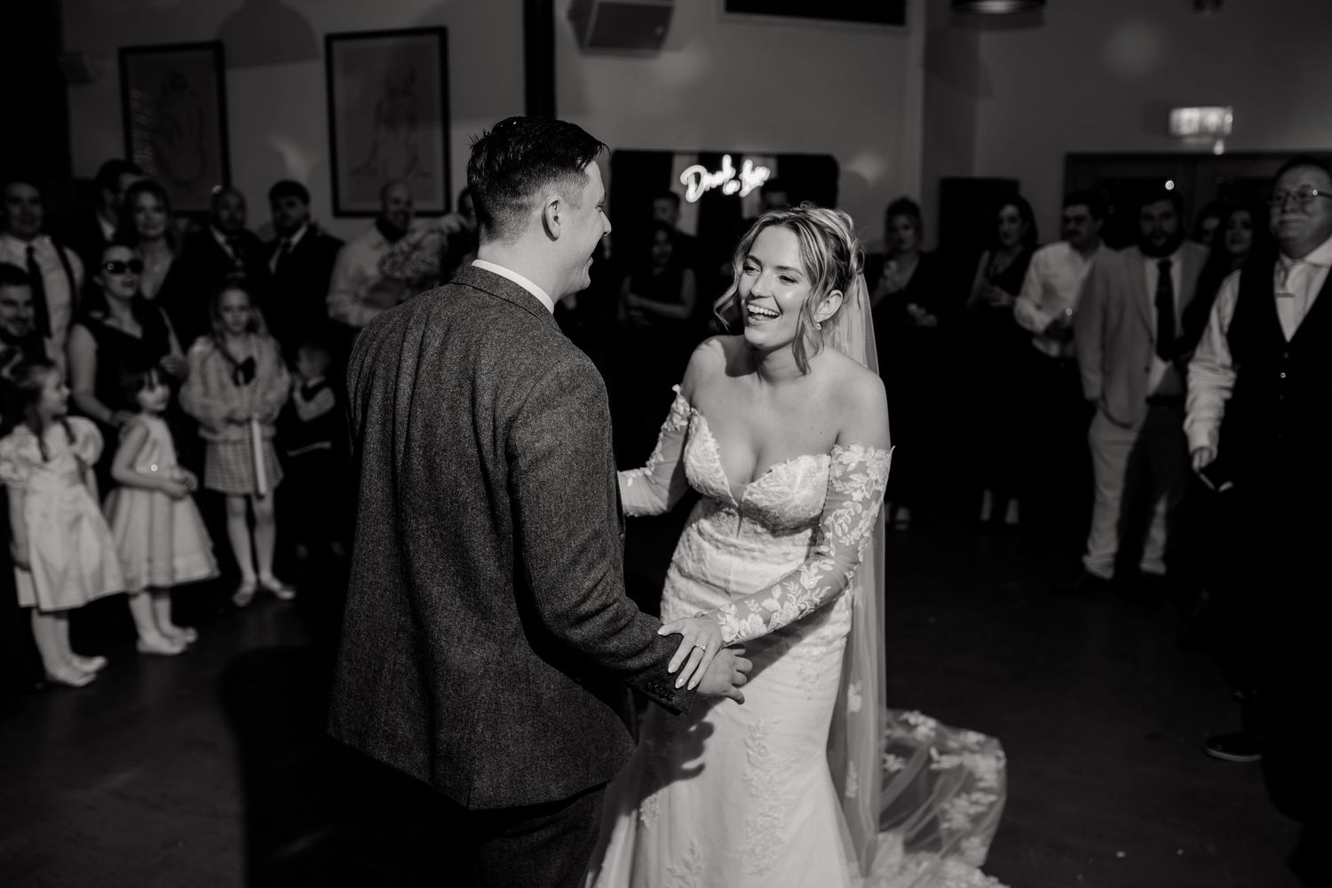 Black and white photo of bride and groom sharing their first dance at wedding reception.