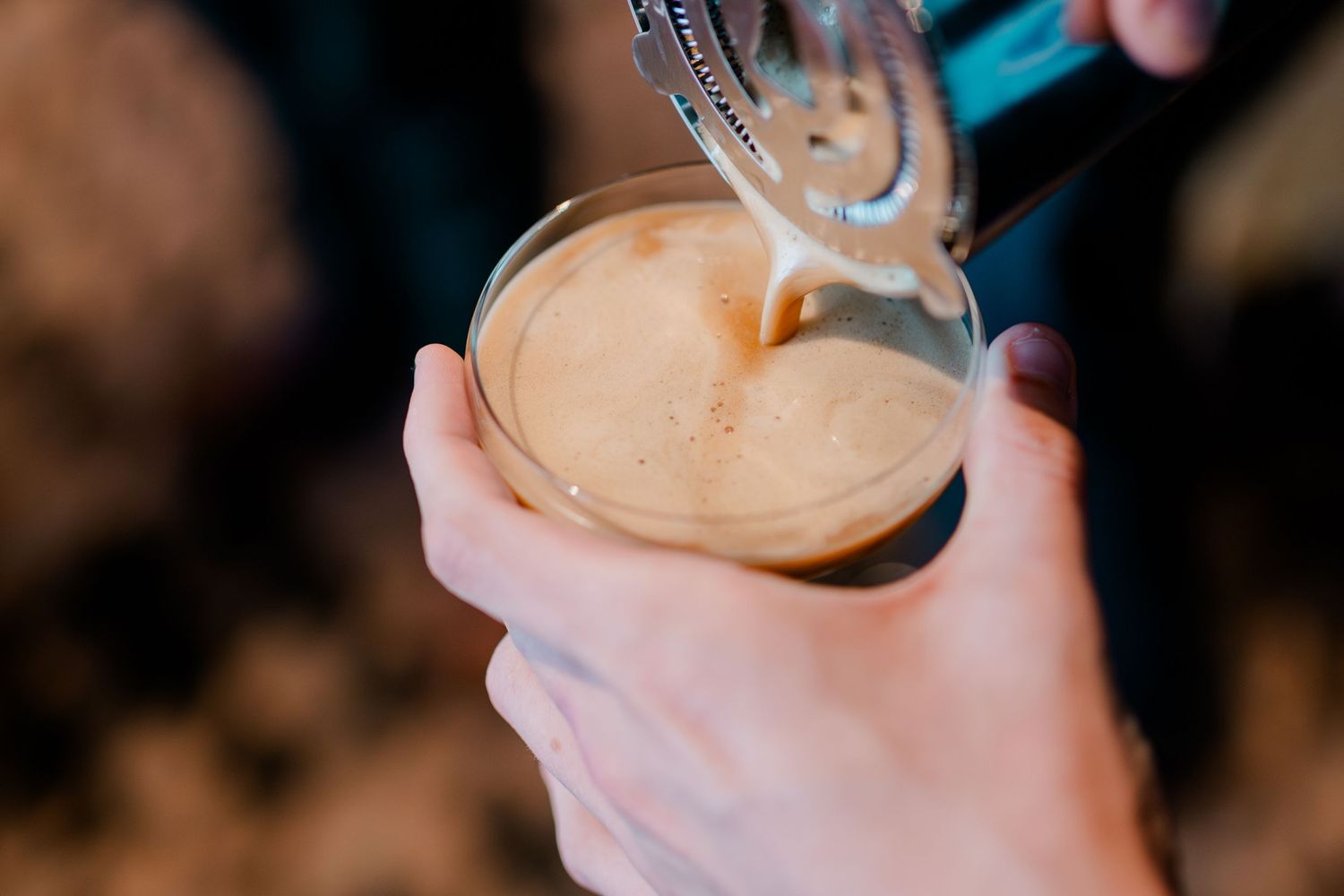 Bartender pouring a fresh craft beer into a glass at an outdoor wedding celebration event.