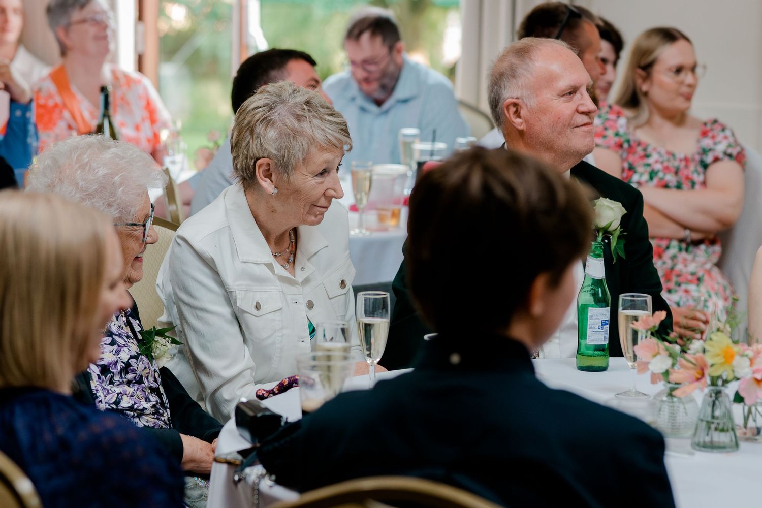 Wedding reception guests enjoying dinner and conversation at decorated tables.