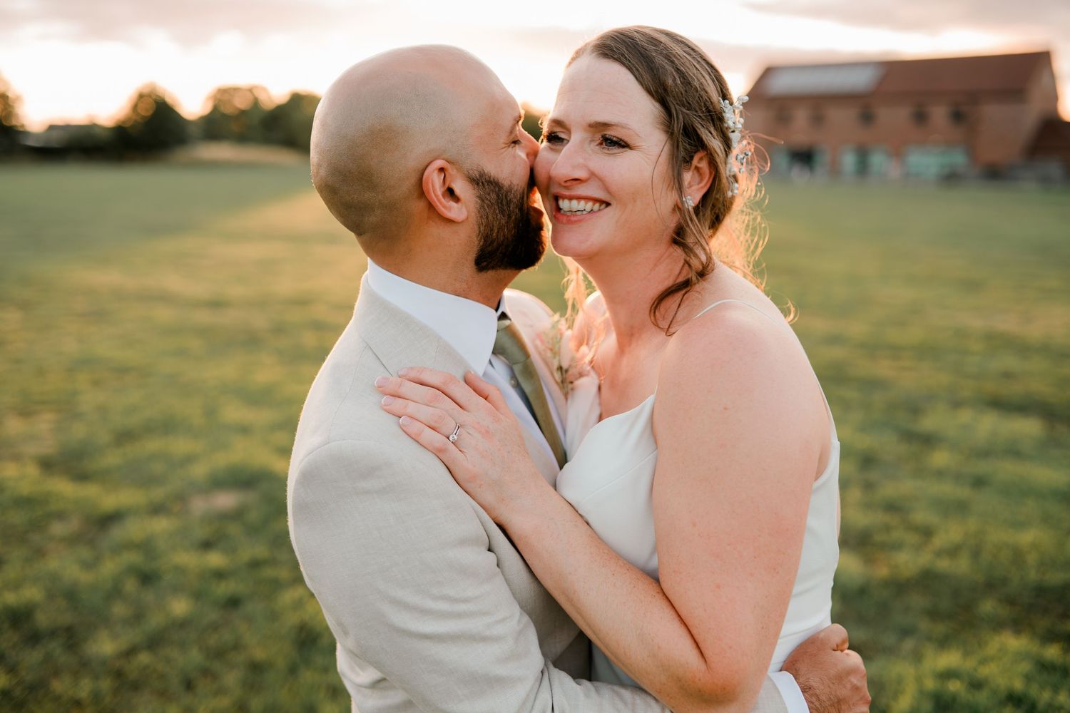 Intimate sunset portrait of newlyweds embracing in golden evening light.