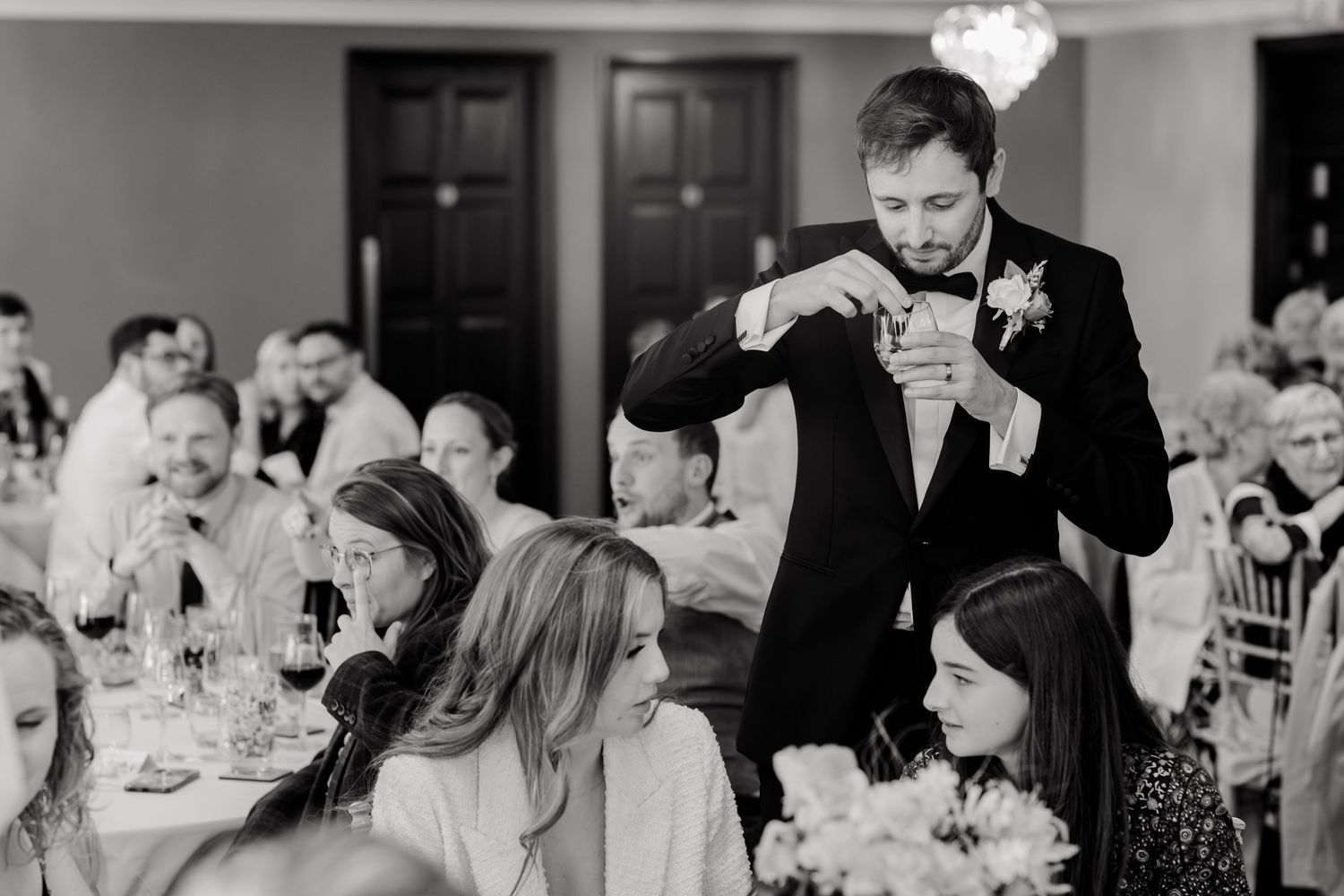 Wedding guests enjoying a reception dinner and dancing in an elegant ballroom setting.