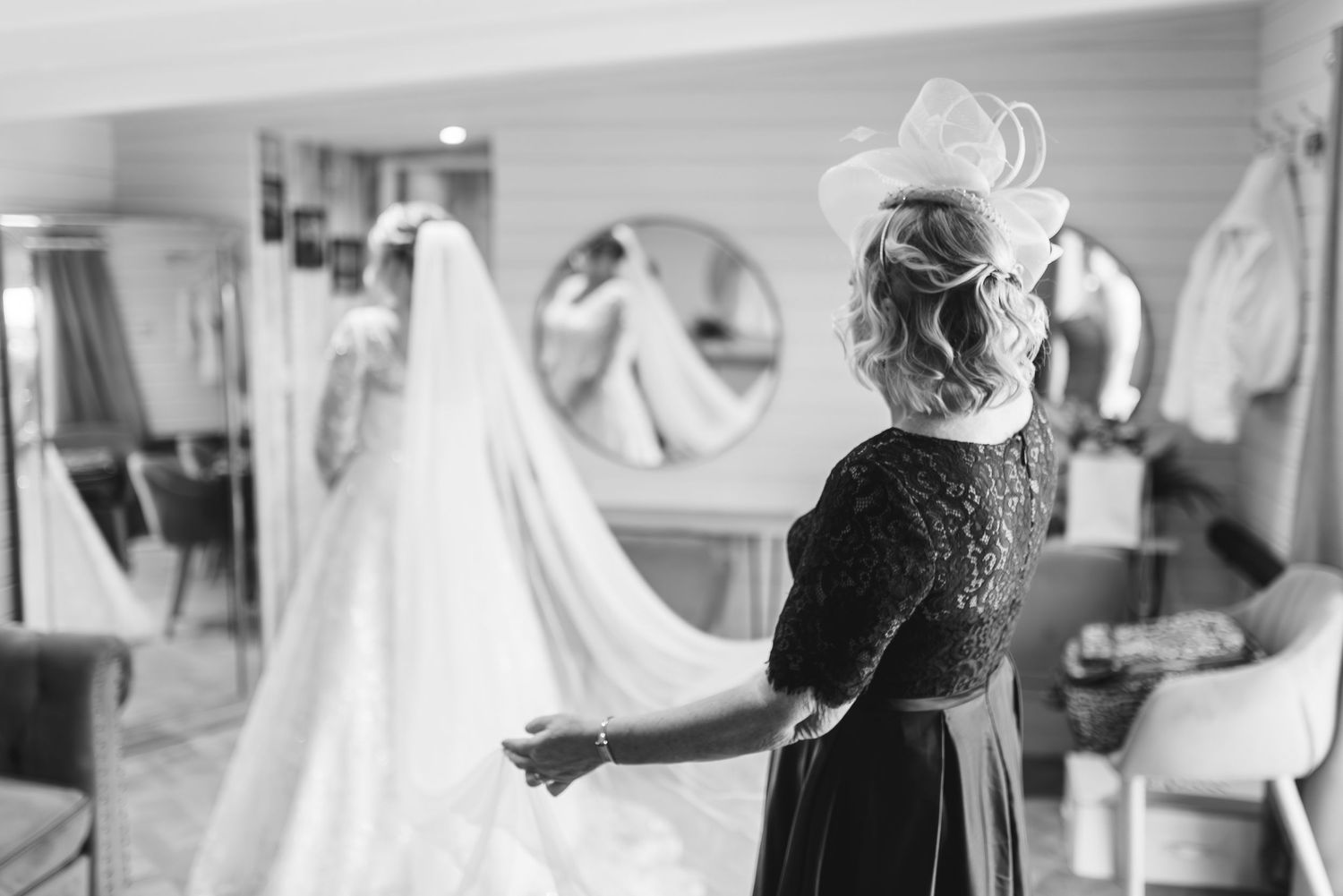 Black and white photo of wedding dress preparations in a bridal suite.