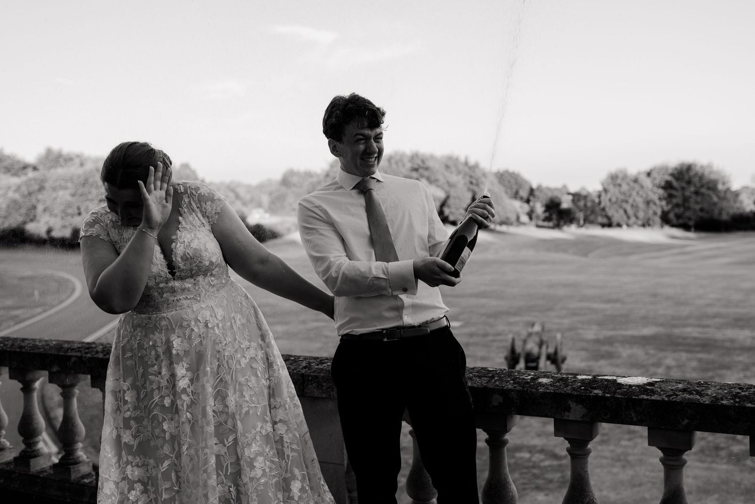 A couple and their friends celebrate with champagne outdoors during a sunny summer wedding reception.