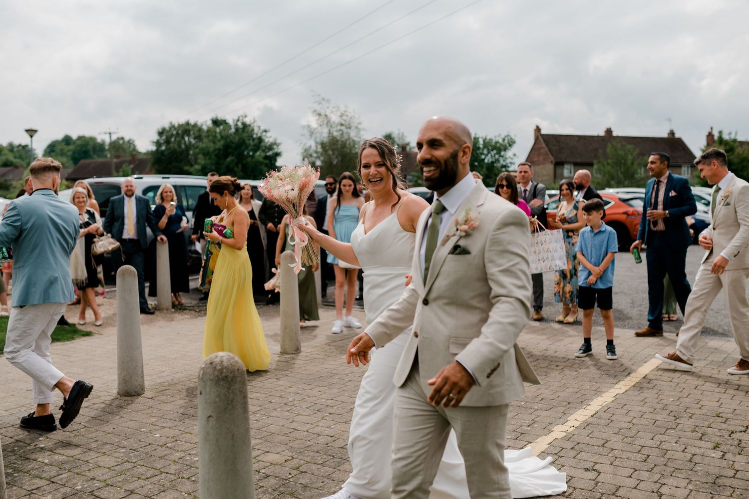 Wedding party dances and celebrates on an outdoor stone patio during a summer celebration.