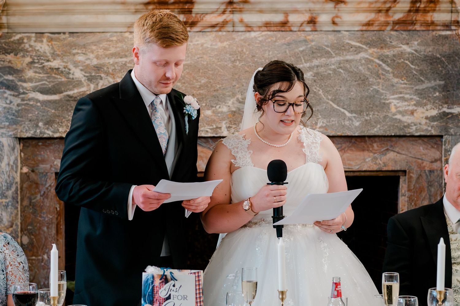 Bride and groom giving a joint speech together at their wedding reception dinner.