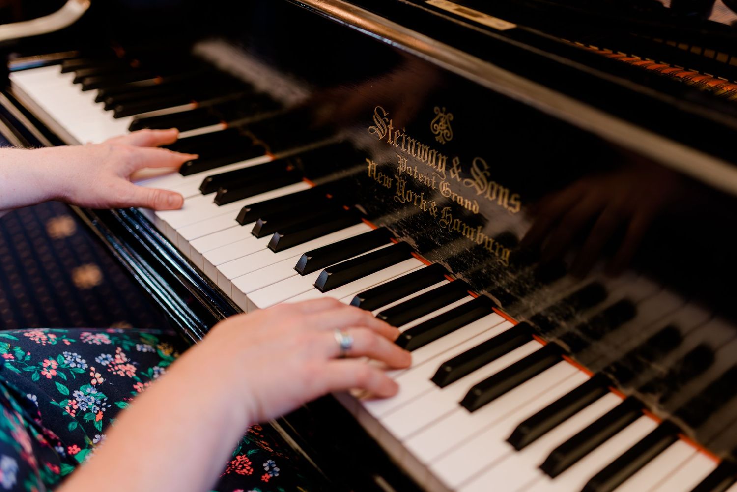 Close-up view of hands playing piano keys during a musical performance.