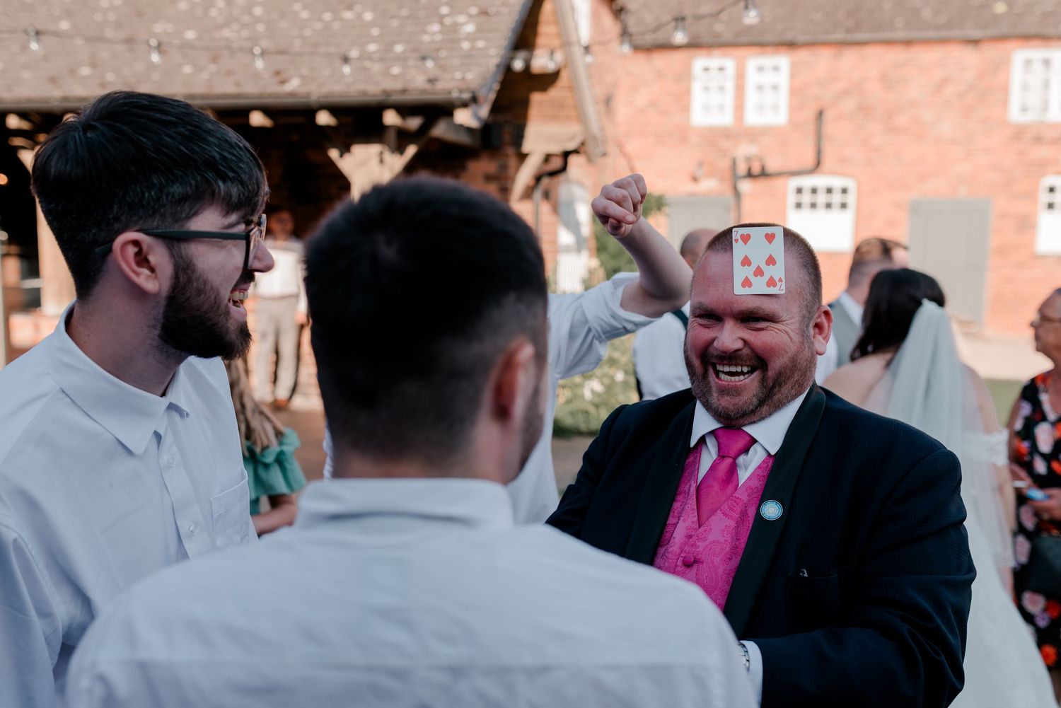 A candid moment of laughter shared between guests at an outdoor wedding reception.
