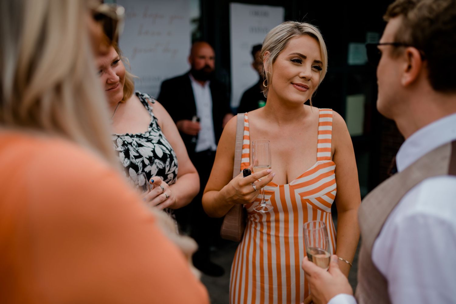 Guests enjoy conversation during a casual outdoor summer wedding reception.