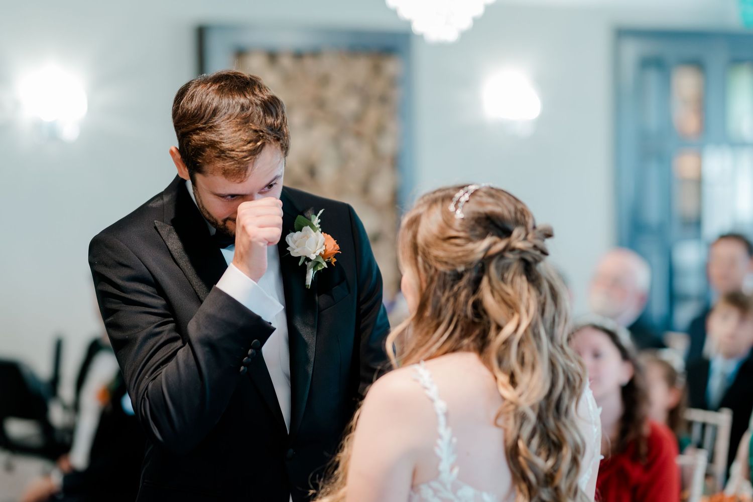 Wedding ceremony in a light blue room with guests watching as couple shares their first dance.