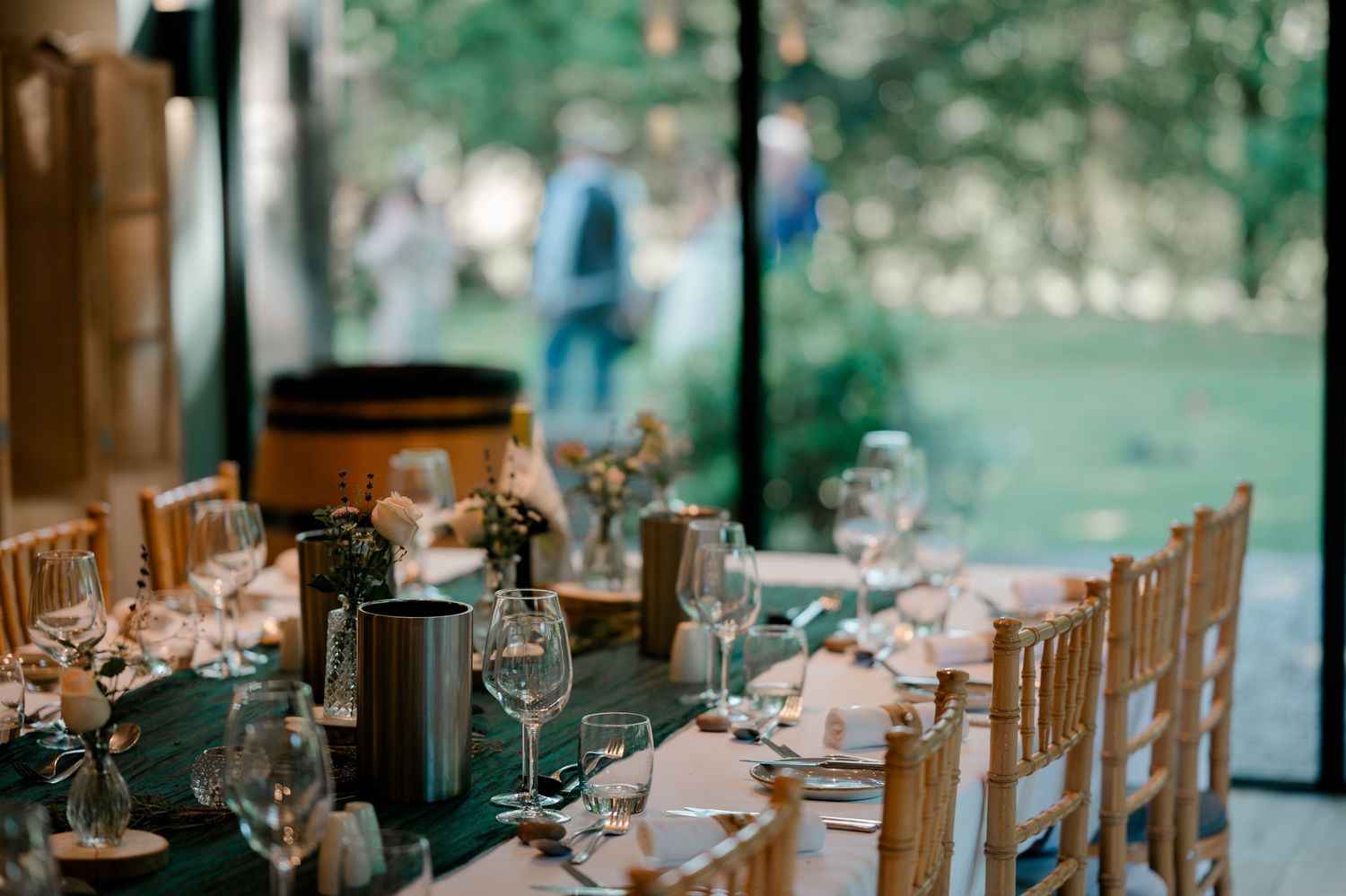Elegantly set wedding reception table with wine glasses in a rustic venue.