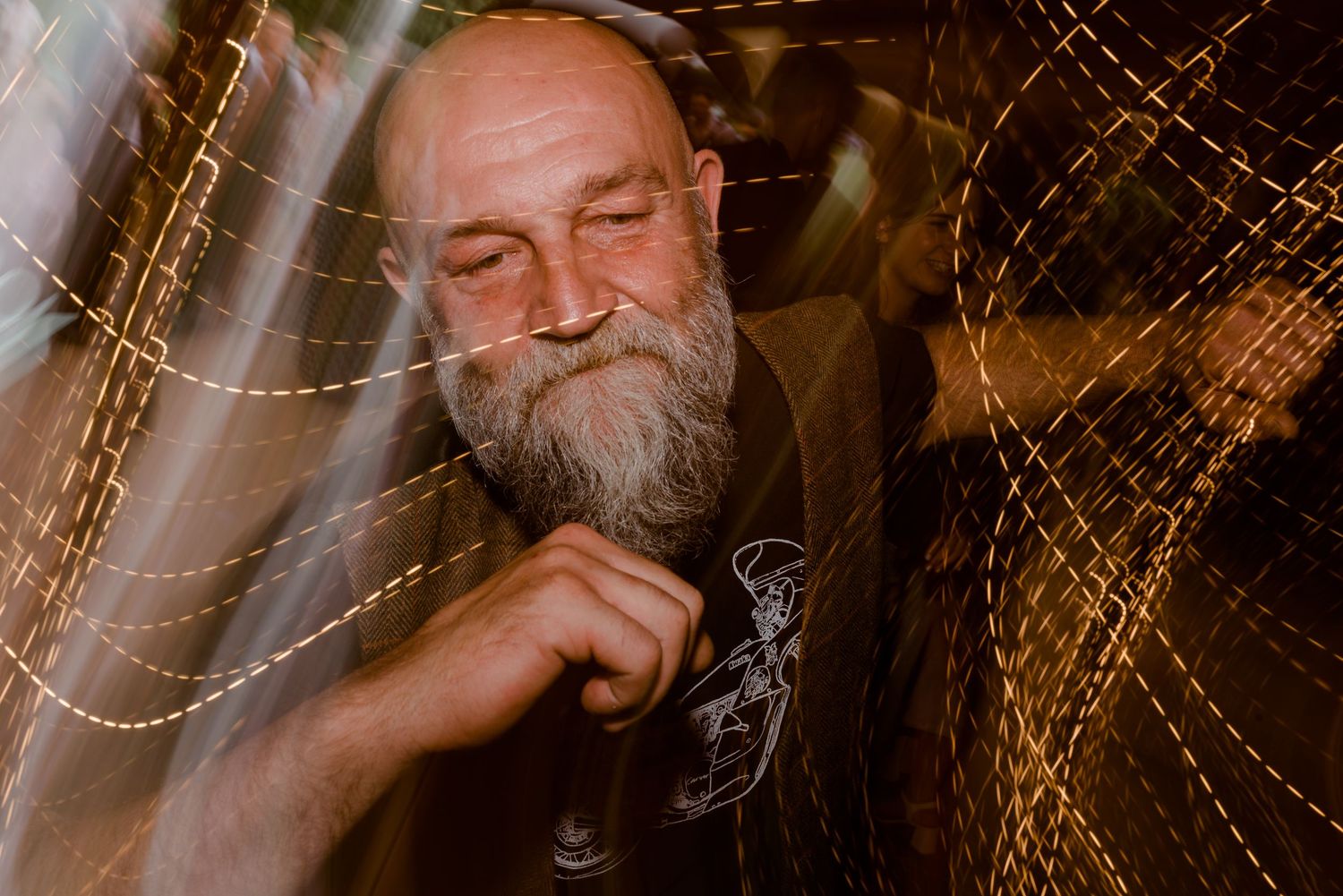 A thoughtful portrait of a bearded man with closed eyes against an artistic textured background.
