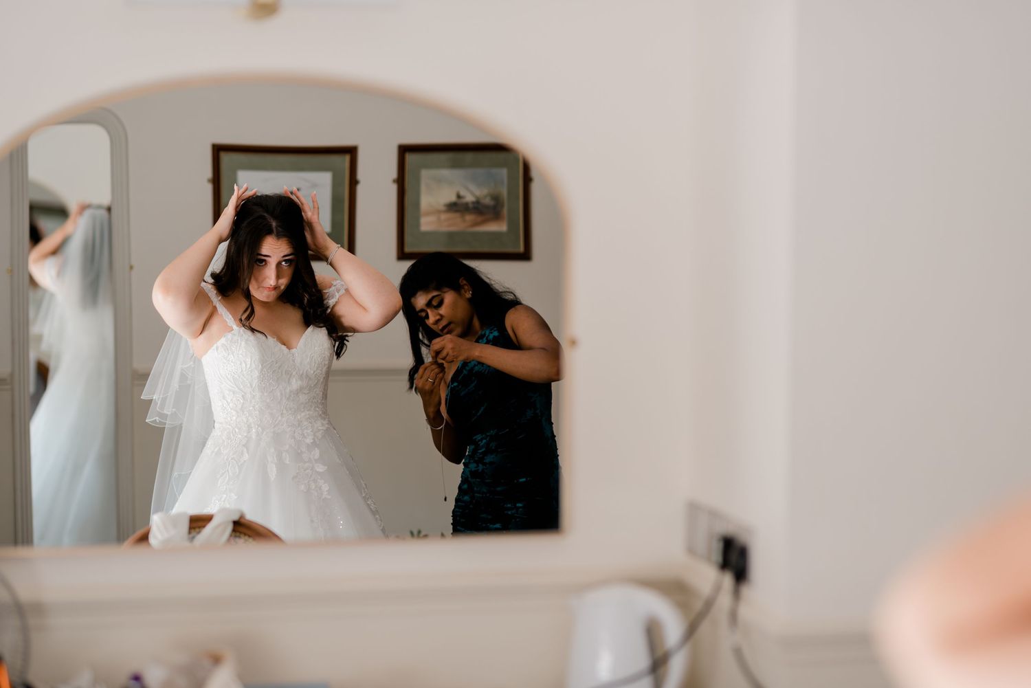 Wedding preparation scene in a bright white room with several people getting ready.