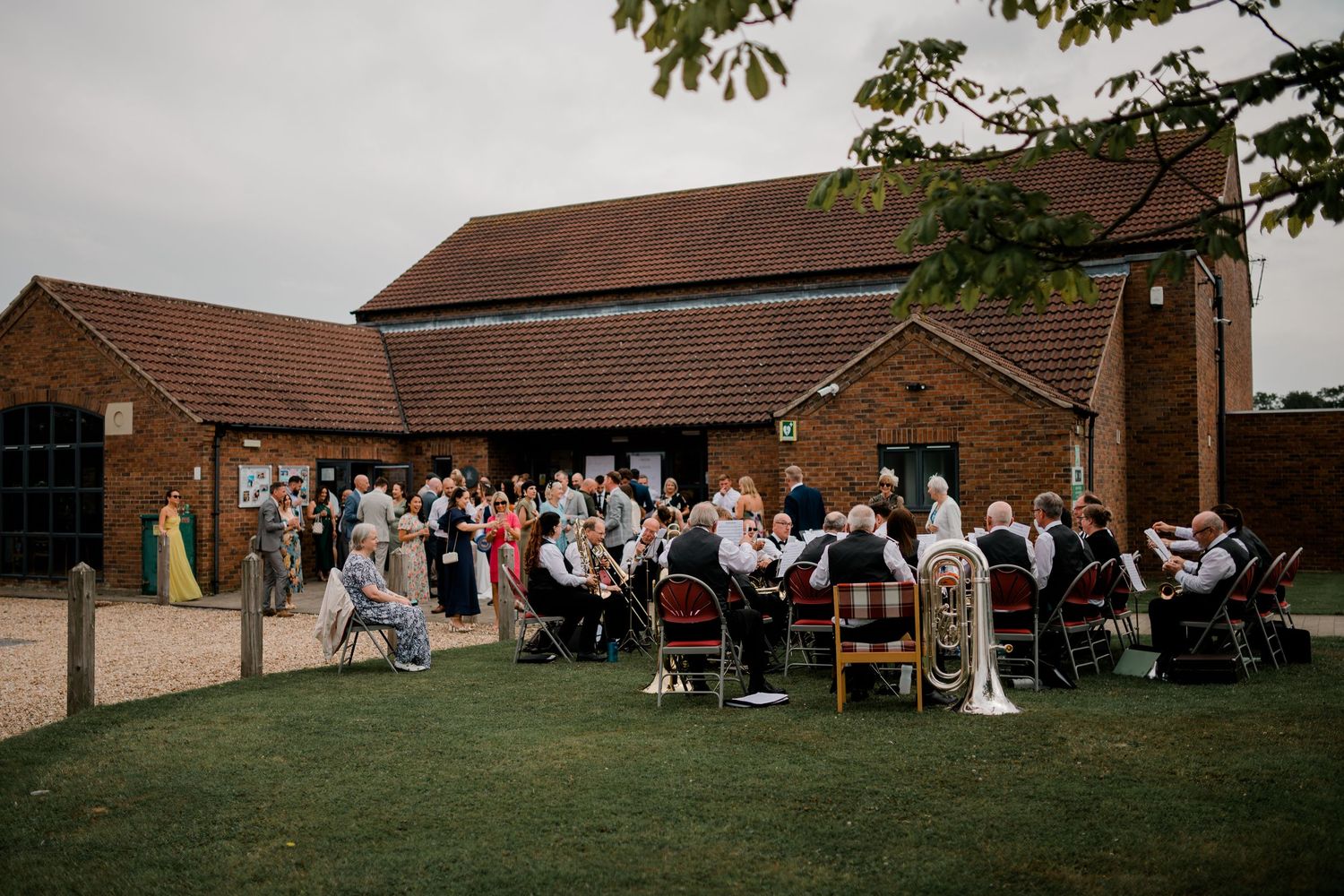 Wedding celebration setup outside a brick church with guests gathering on the lawn.