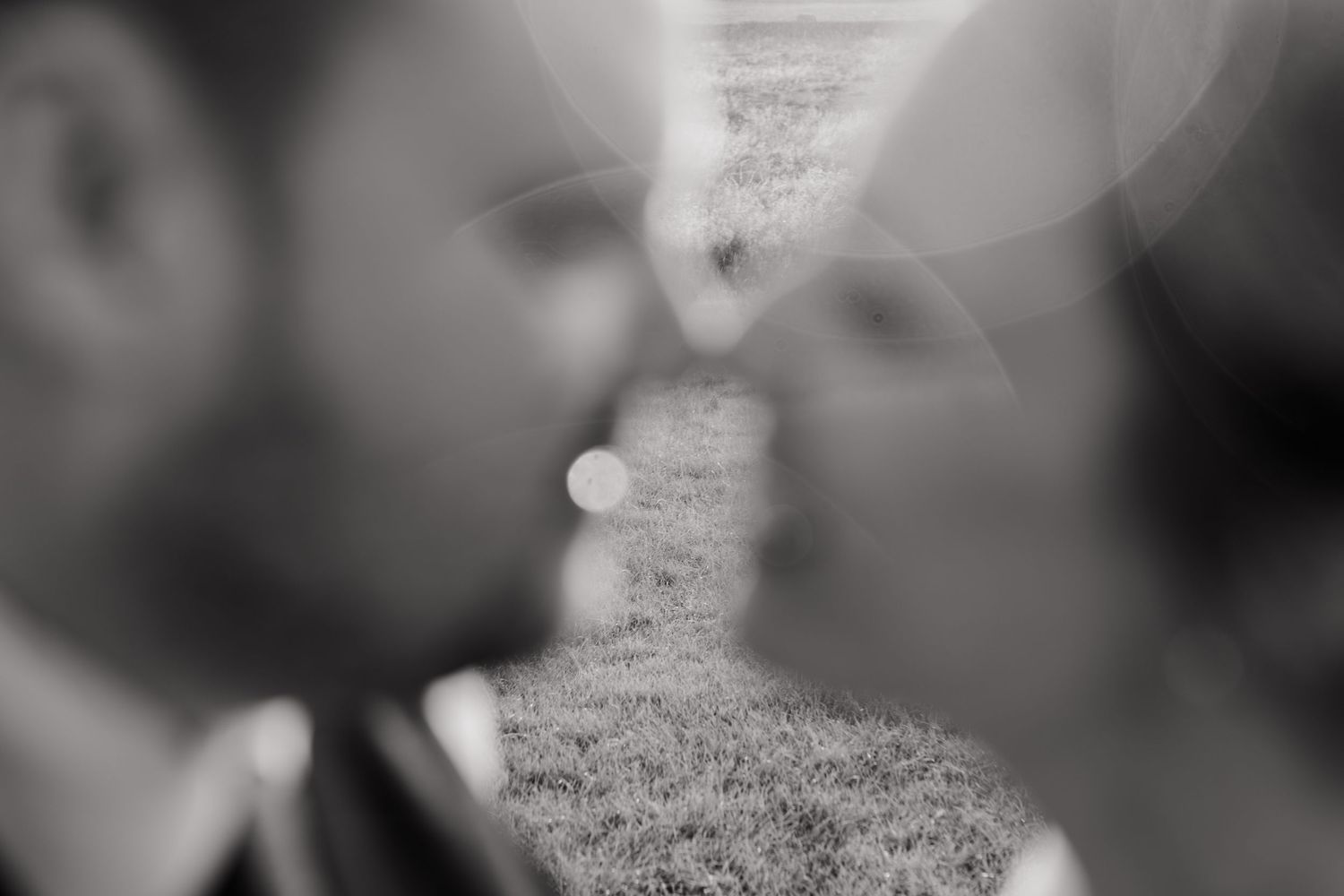 A soft black and white romantic moment between two people about to kiss.