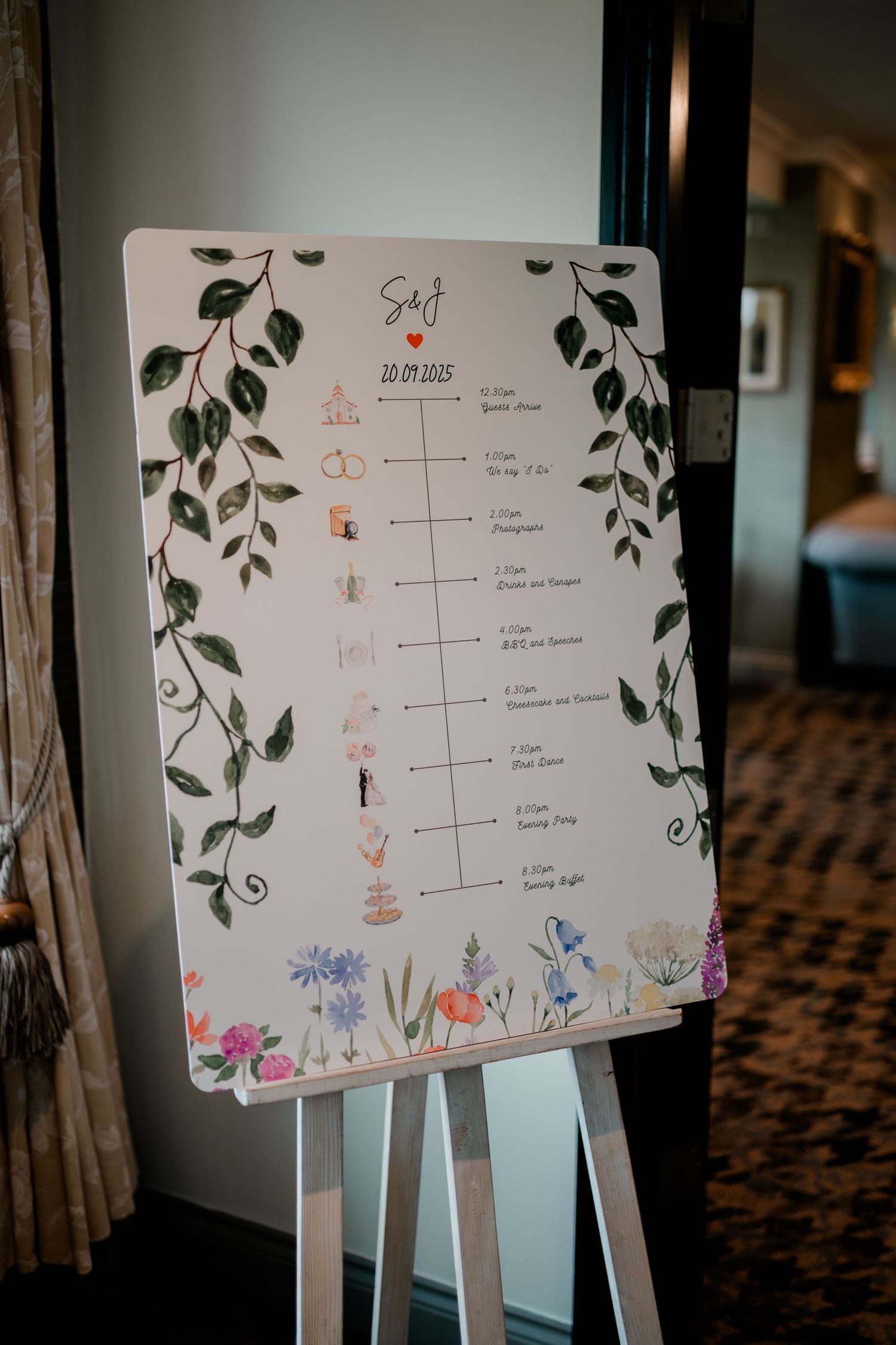 Wedding timeline schedule displayed on white board with floral decorations and elegant handwritten details.