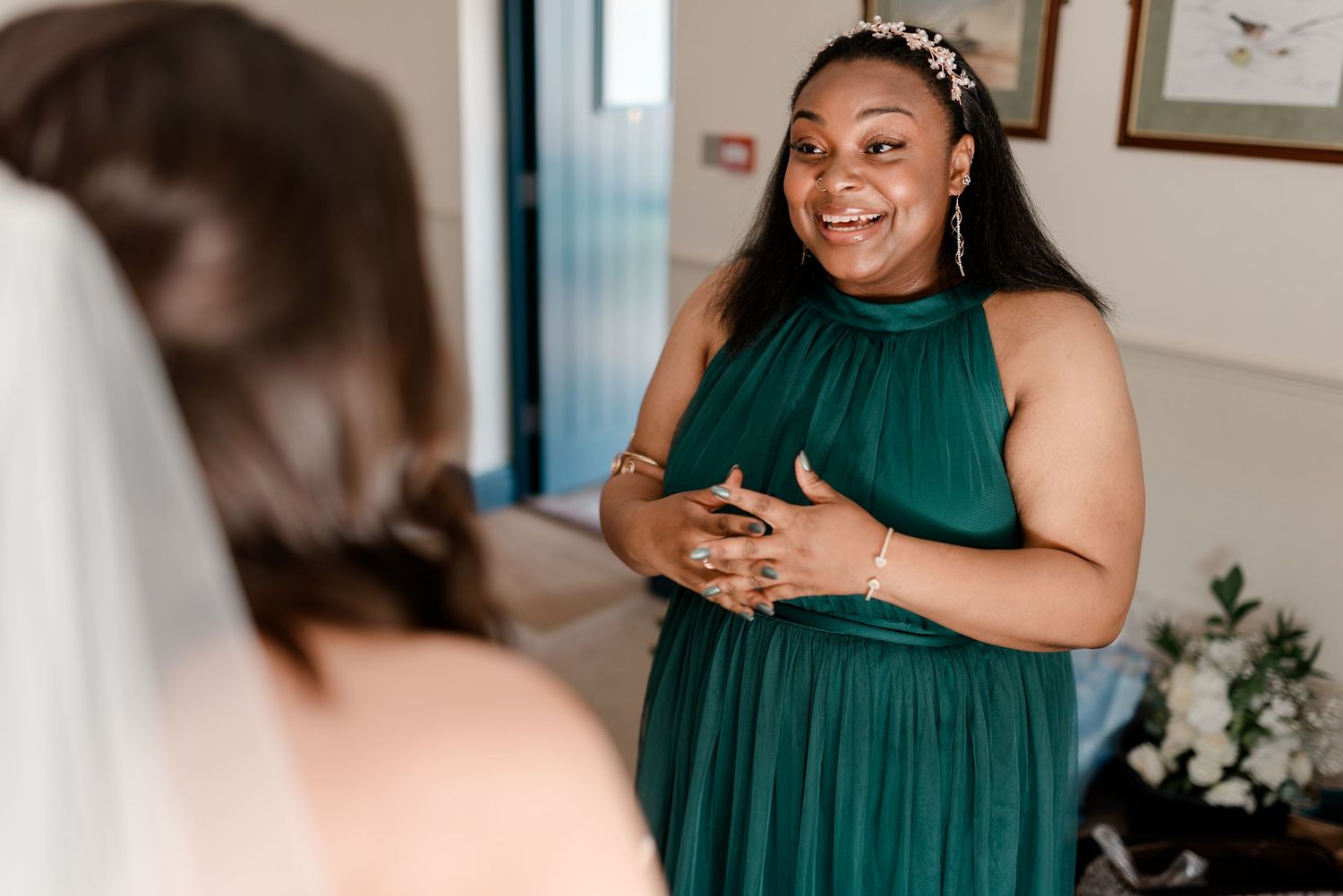 Several bridesmaids in emerald green dresses prepare for a wedding celebration.