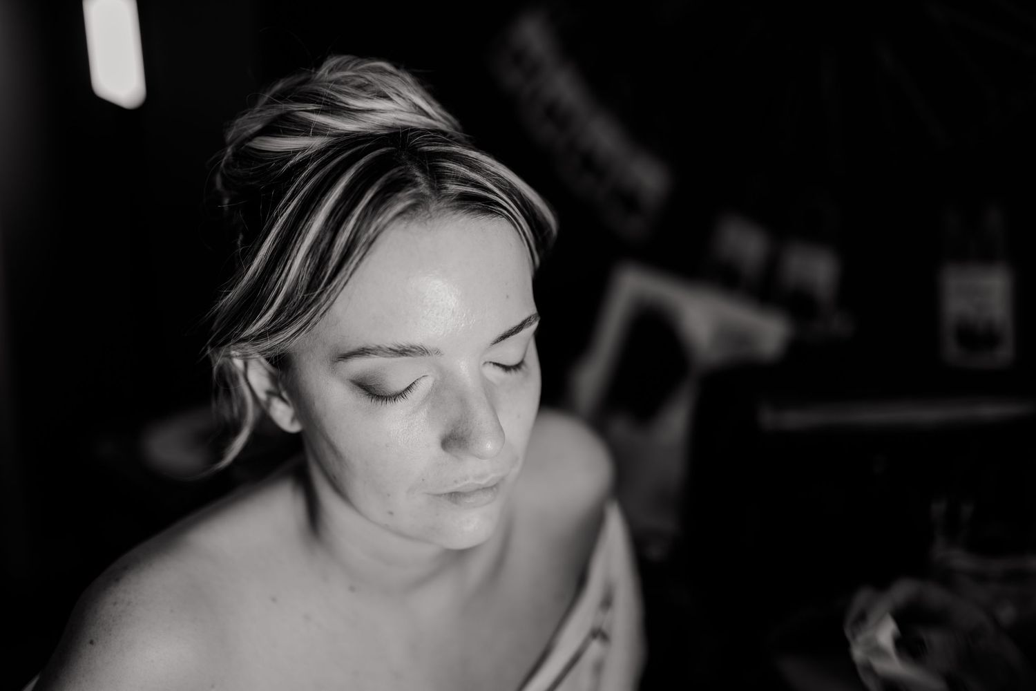 Black and white portrait of a bride with elegant updo getting ready on her wedding day.