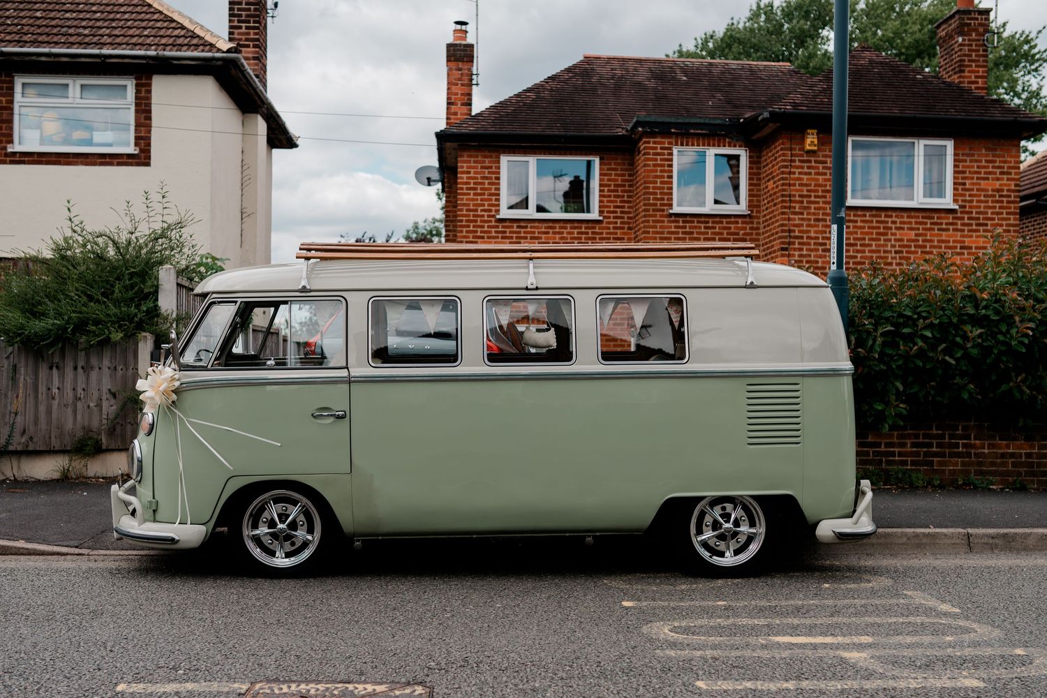 Vintage mint green Volkswagen van parked on residential street.