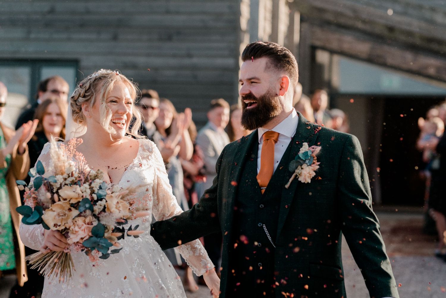 Newlyweds celebrate with confetti during their outdoor wedding celebration.