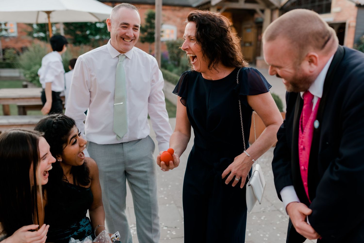Casual outdoor wedding reception gathering with guests interacting on a summer evening.
