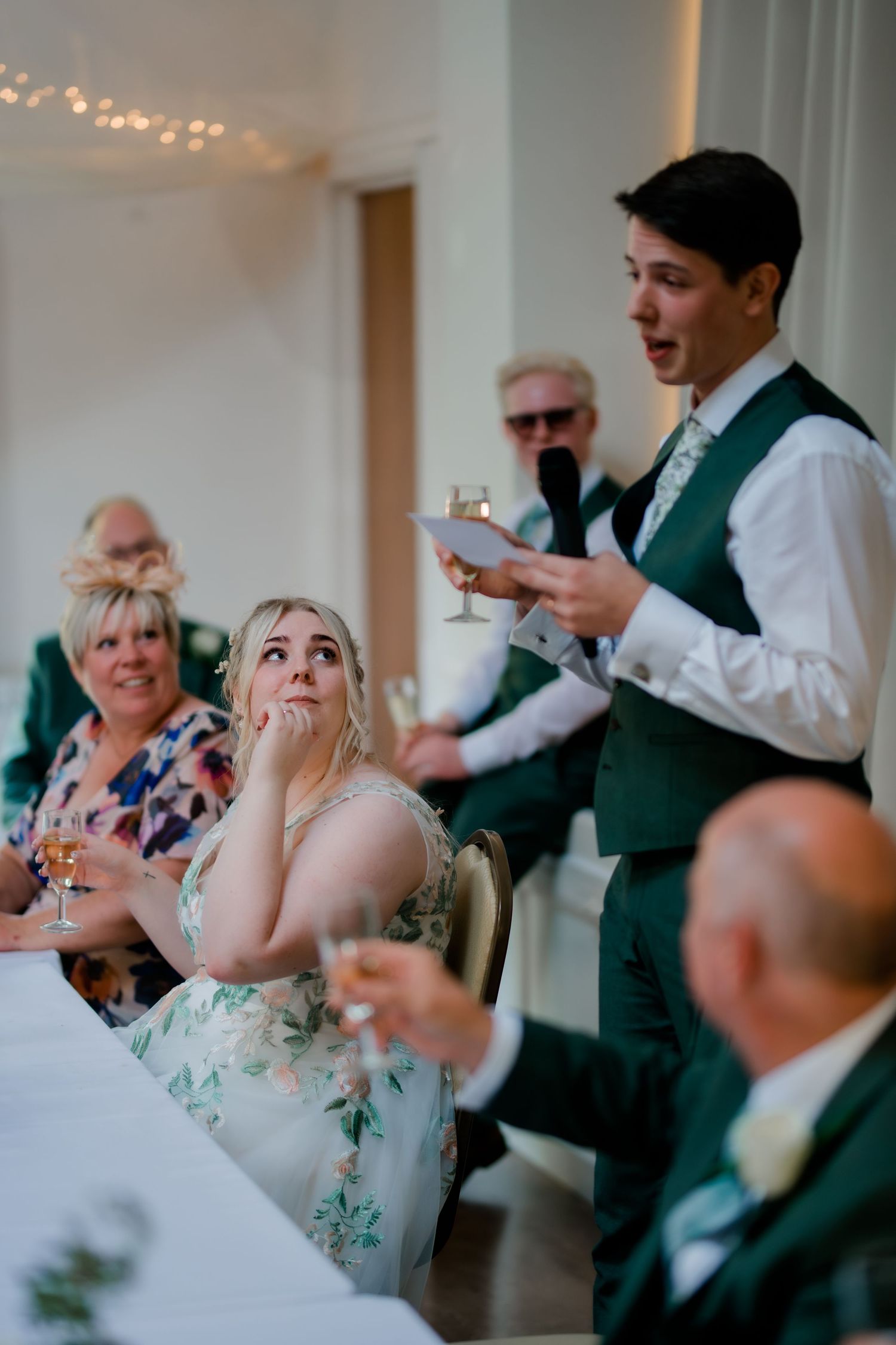 Wedding reception celebration with guests and servers in formal attire.