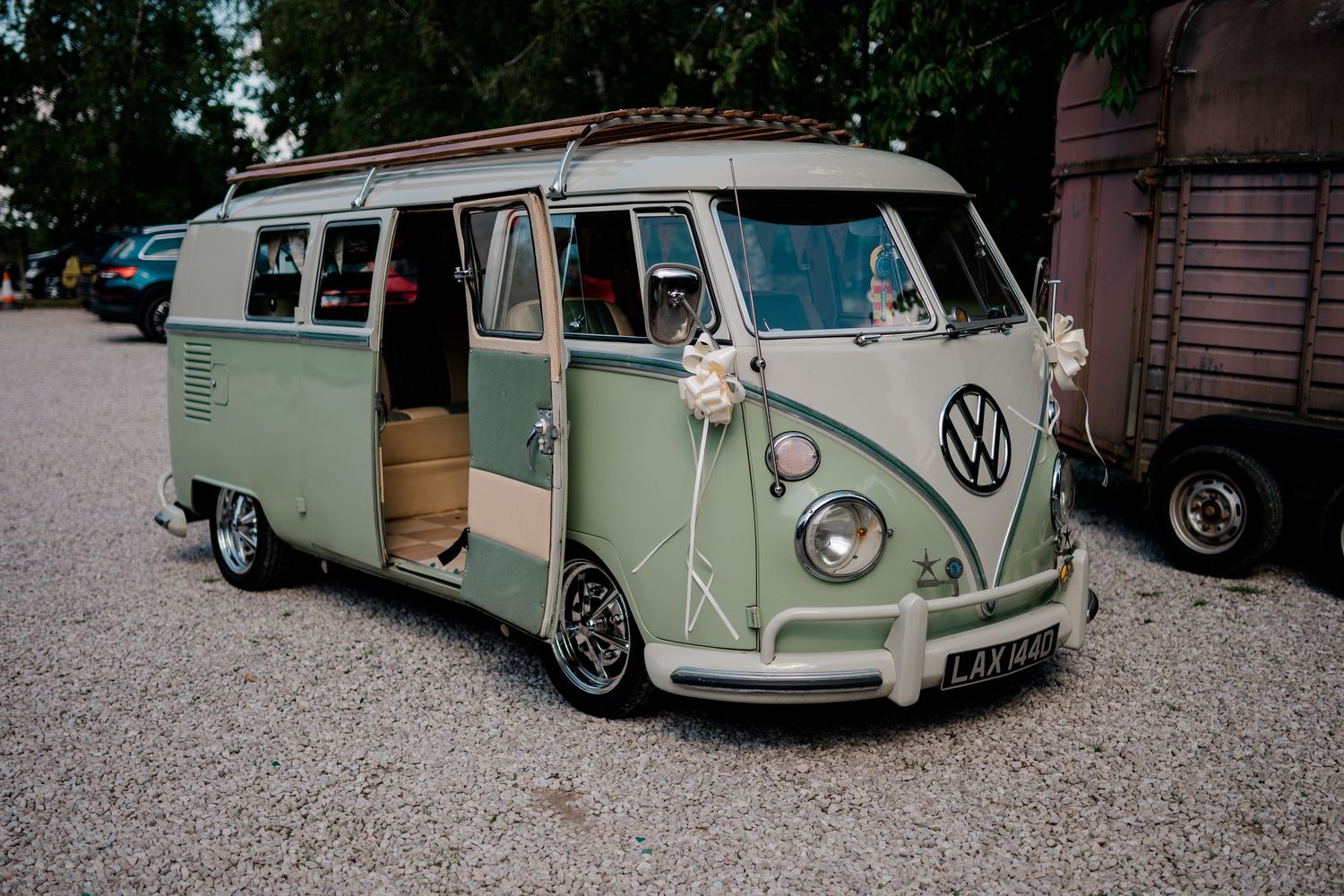 Classic vintage Volkswagen buses lined up at a wedding venue.