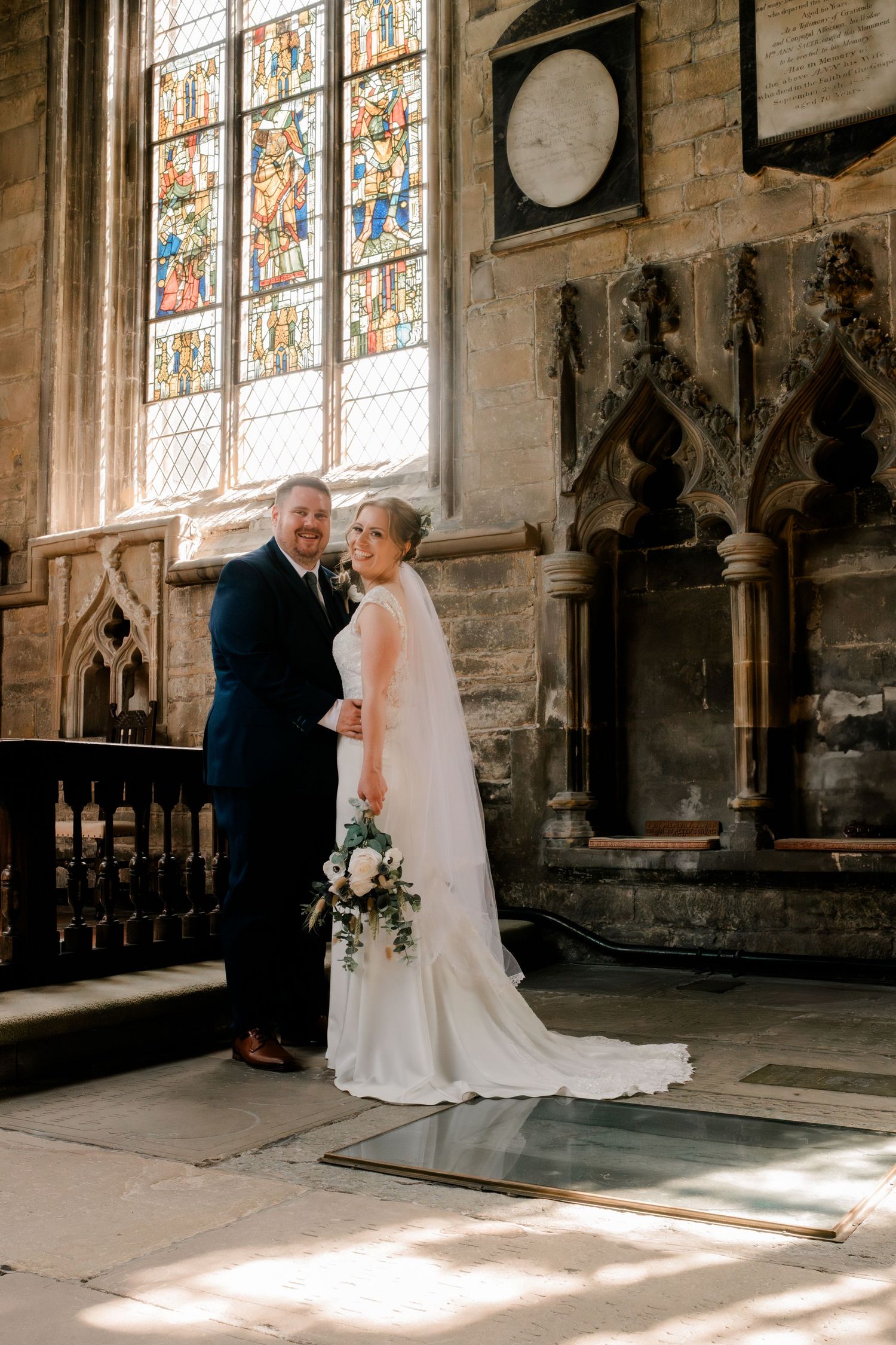 Elegant wedding ceremony in a historic church with stained glass windows casting beautiful natural light.