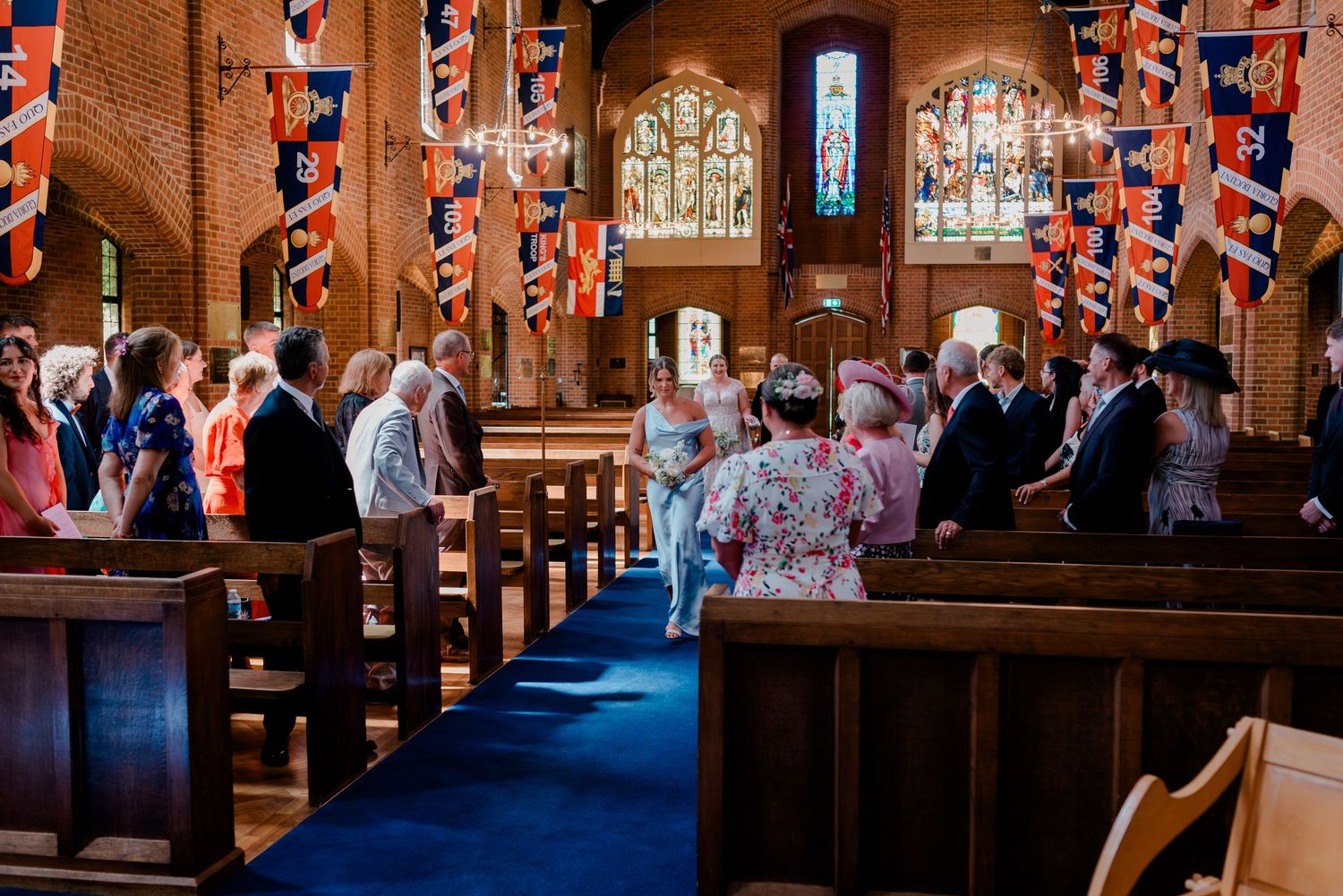 The happy couple shares their first kiss in a traditional wooden church surrounded by wedding guests.