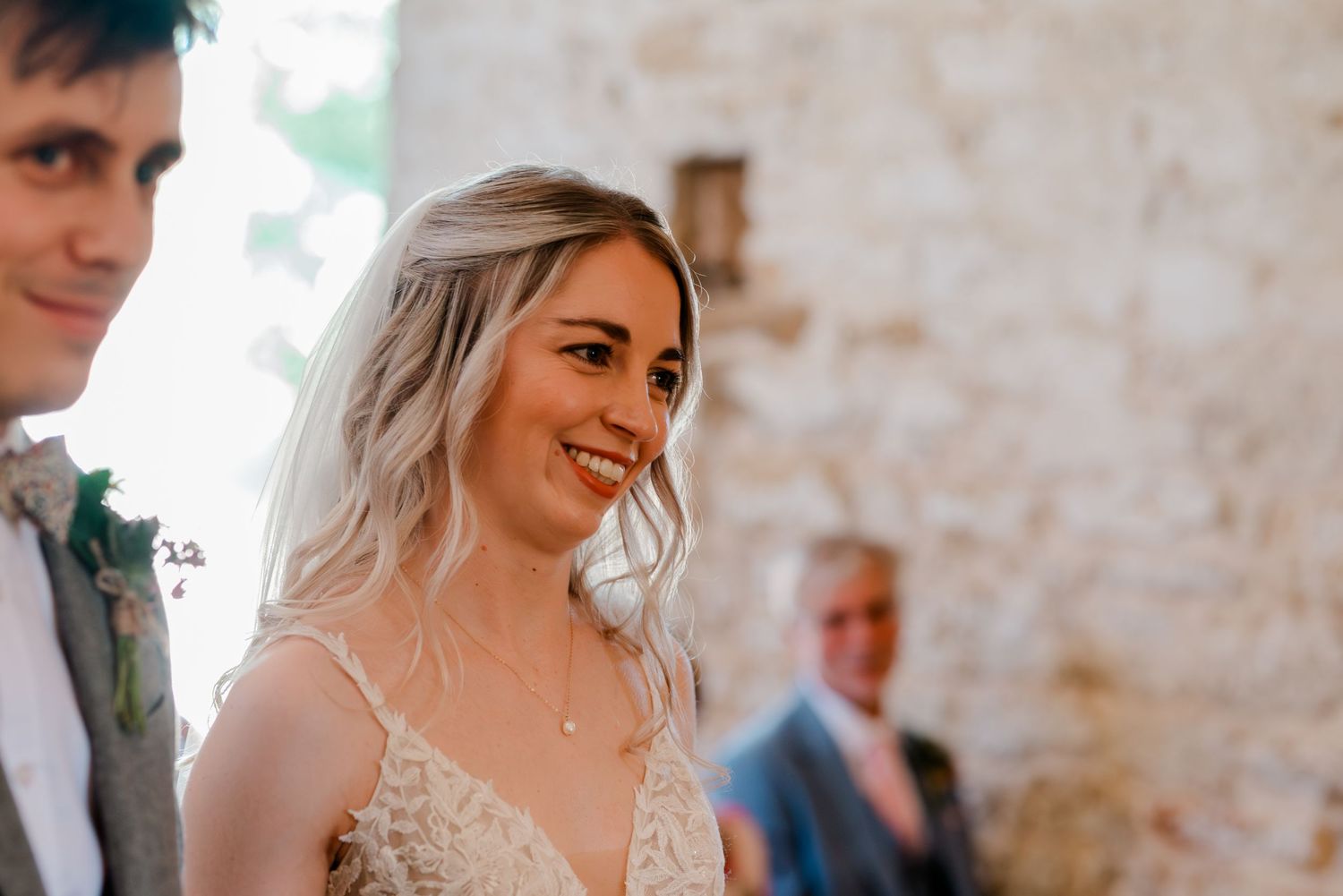 Wedding celebration with guests gathered in a rustic stone-walled venue.
