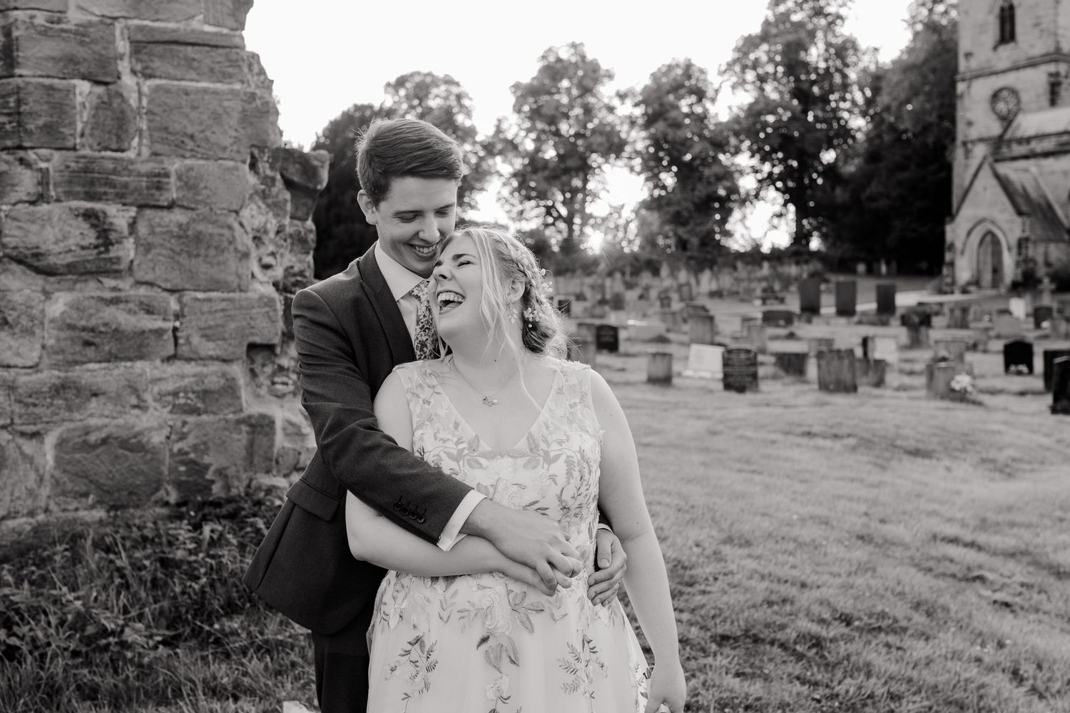 Black and white wedding photo taken near old stone church ruins.
