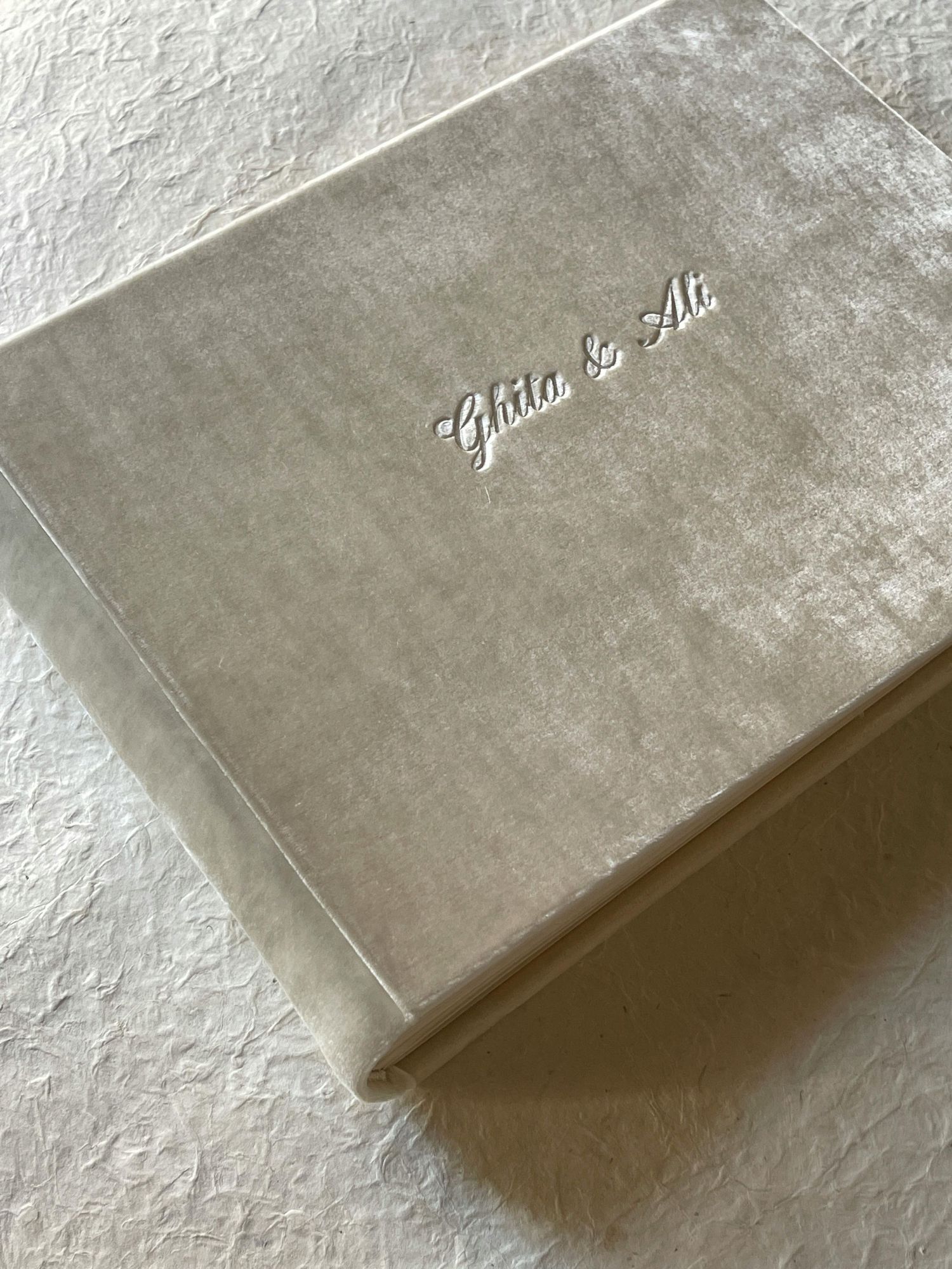 A velvet wedding album with elegant silver text embossed on its cover.