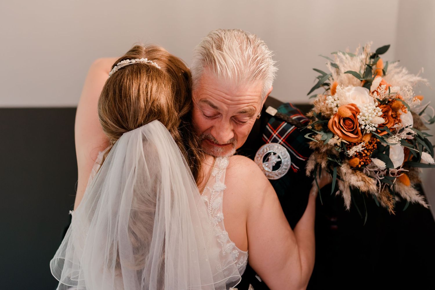 A collection of intimate candid moments between family members hugging and sharing joyful emotions at a wedding.