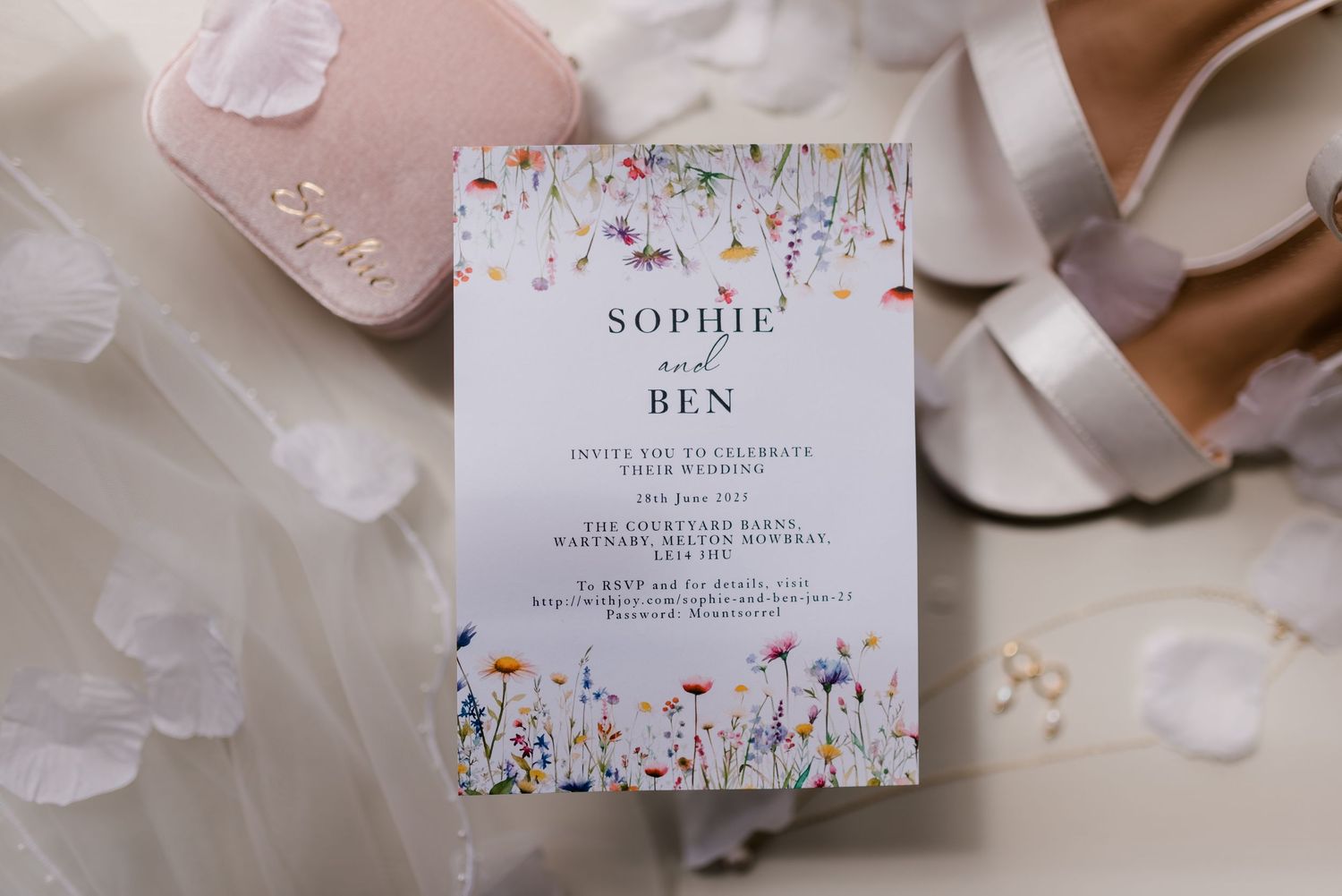 Wildflower wedding invitation for Sophie and Ben displayed with bridal accessories.