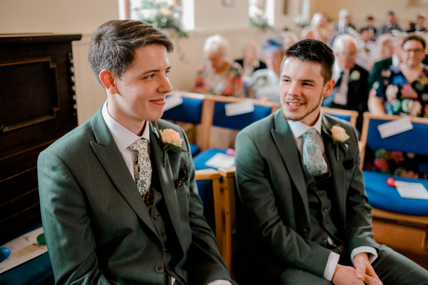 Wedding guests seated in church pews during ceremony.