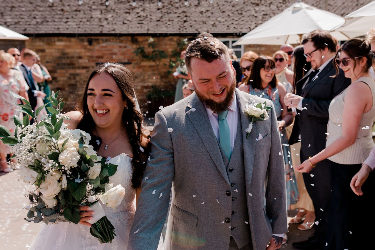 A joyful wedding celebration on a sunny day with elegant floral bouquets.