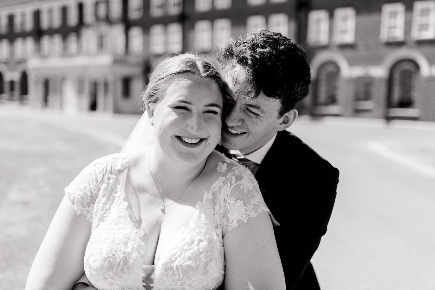 Couple shares romantic moments against architectural backdrop.