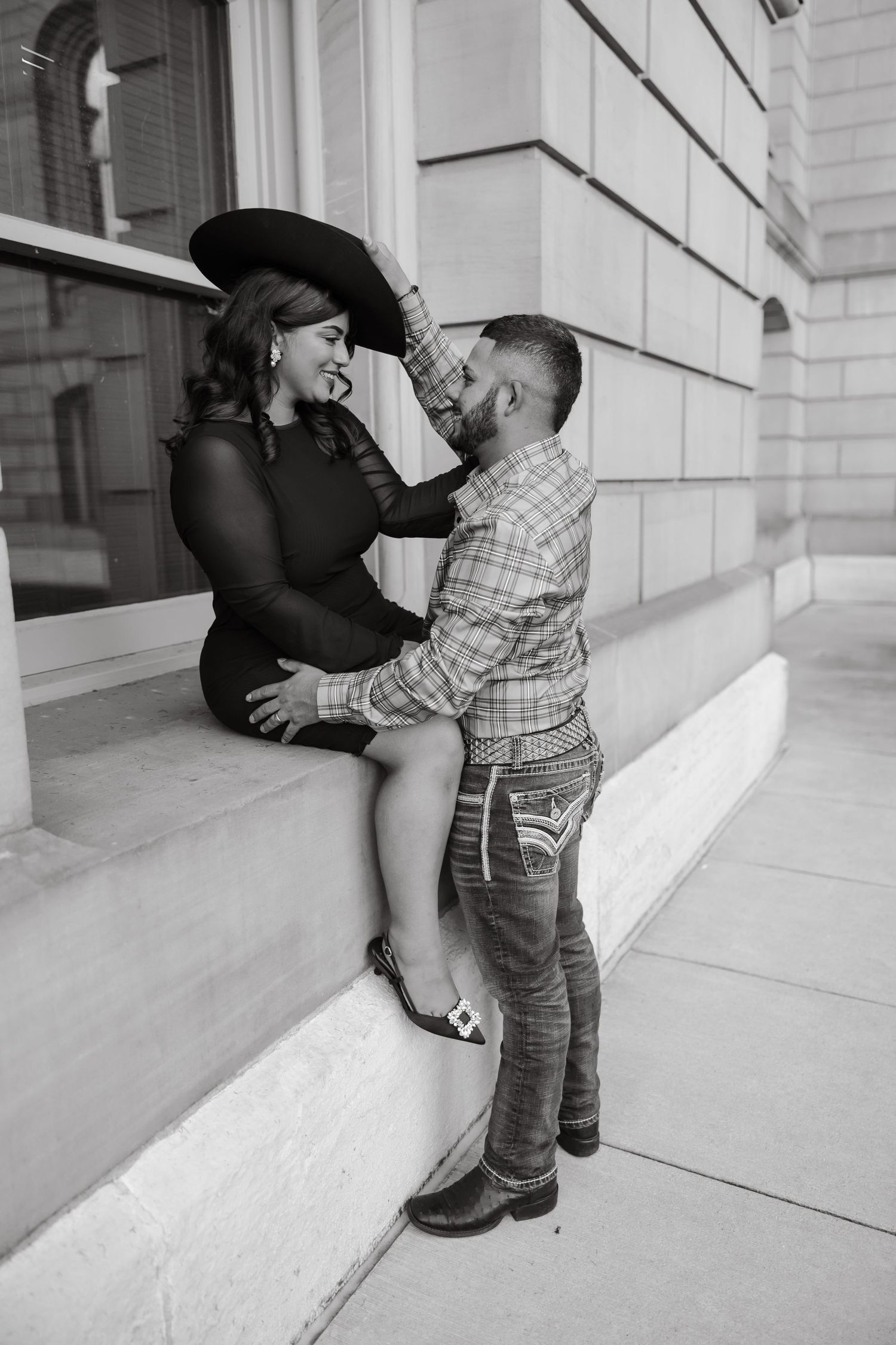 A playful engagement photo sequence showing a couple posing against a white building exterior.