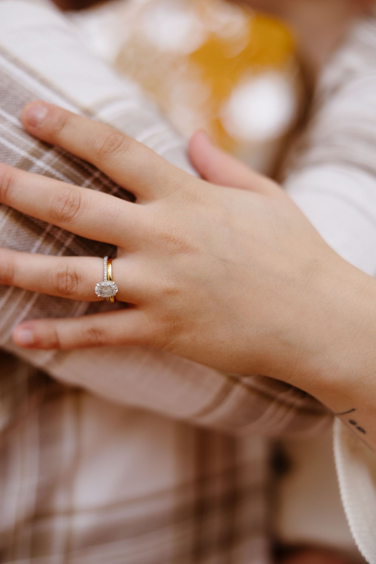 Close-up shot of an engagement ring on a hand with soft autumn lighting.