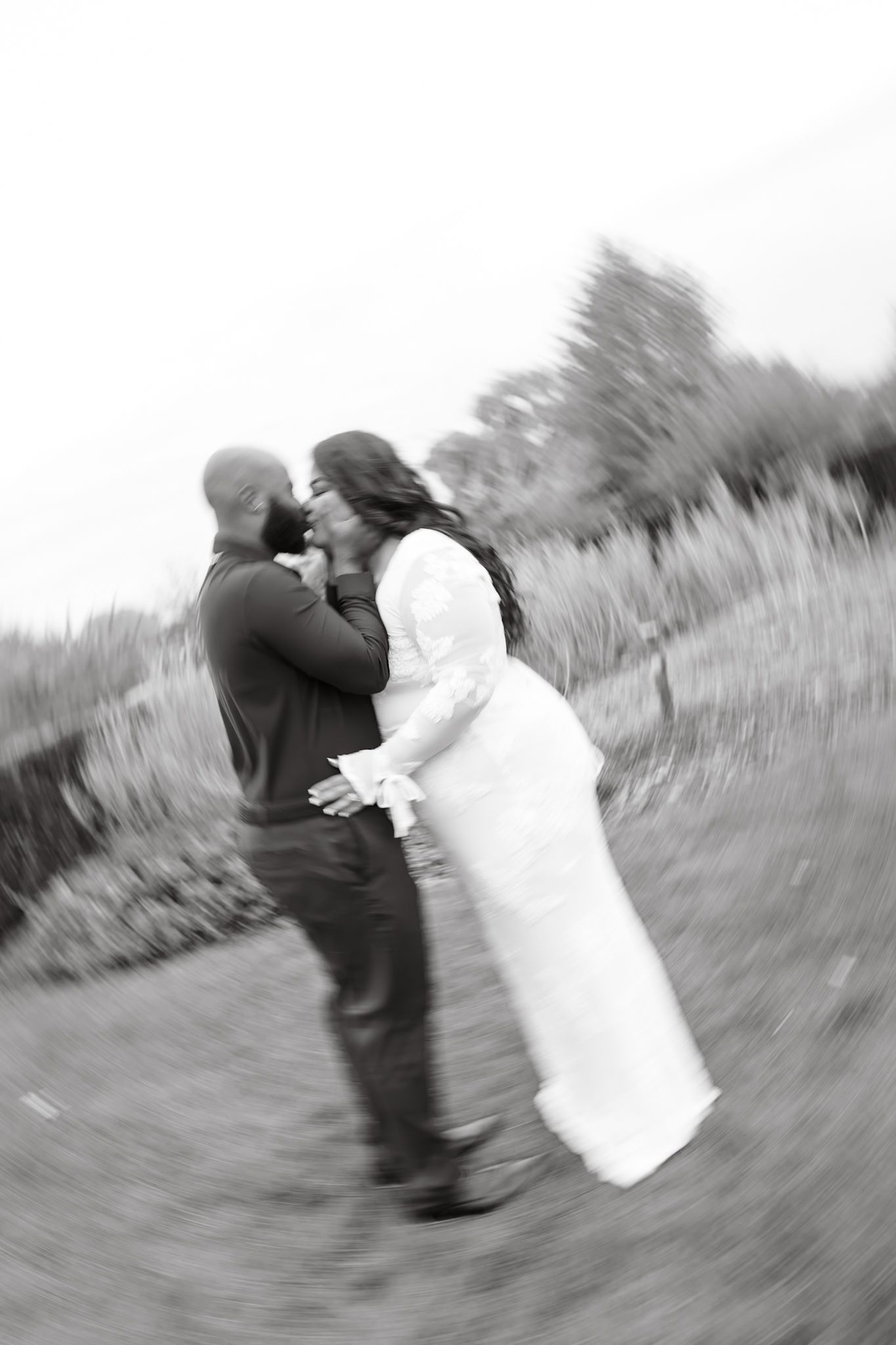 Black and white artistic sequence showing a couple dancing and spinning together in a field.