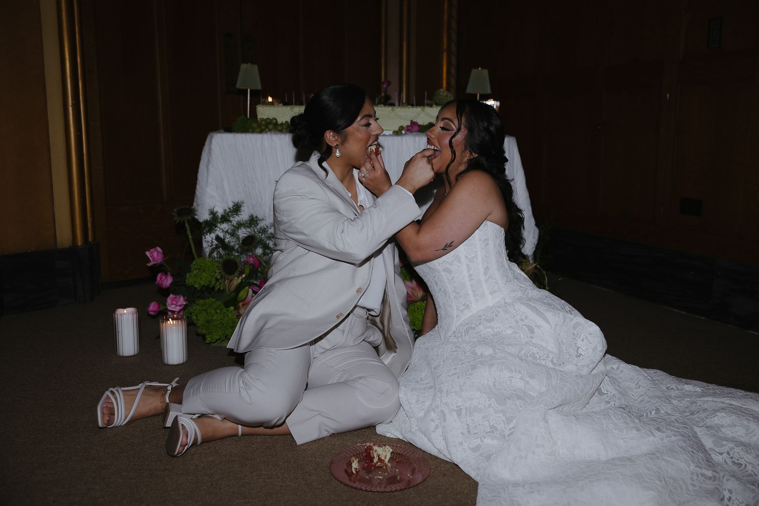Two people in wedding attire share a tender moment on the dance floor during their reception celebration.